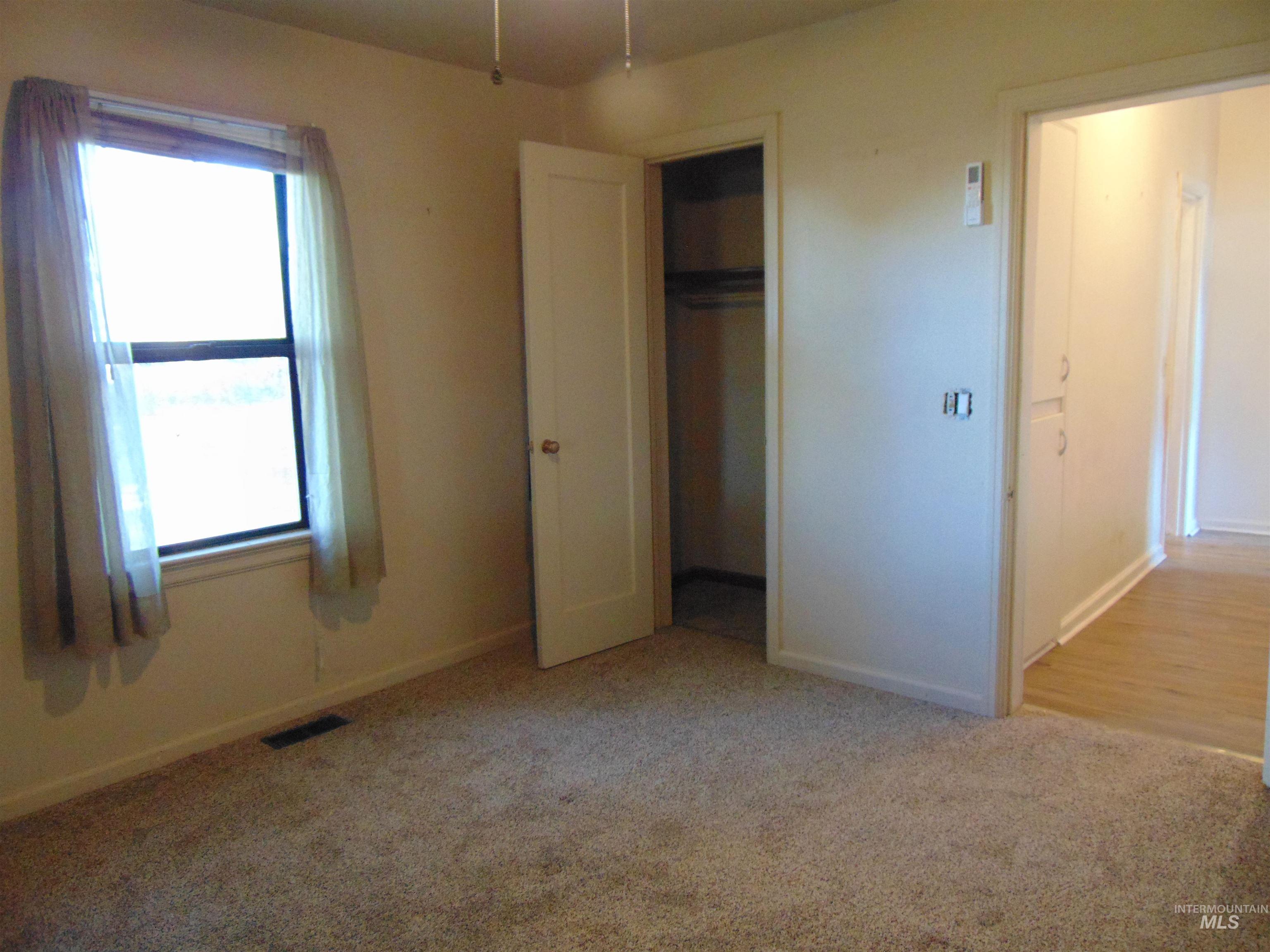 Unfurnished bedroom featuring light carpet and a closet