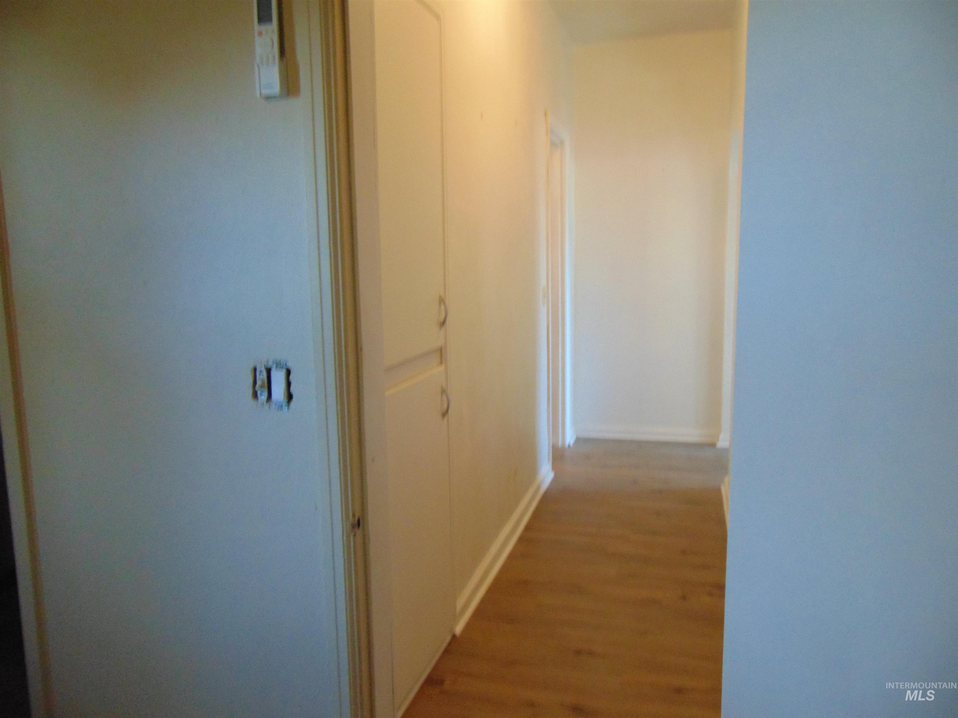 Hall featuring wood finished floors and baseboards