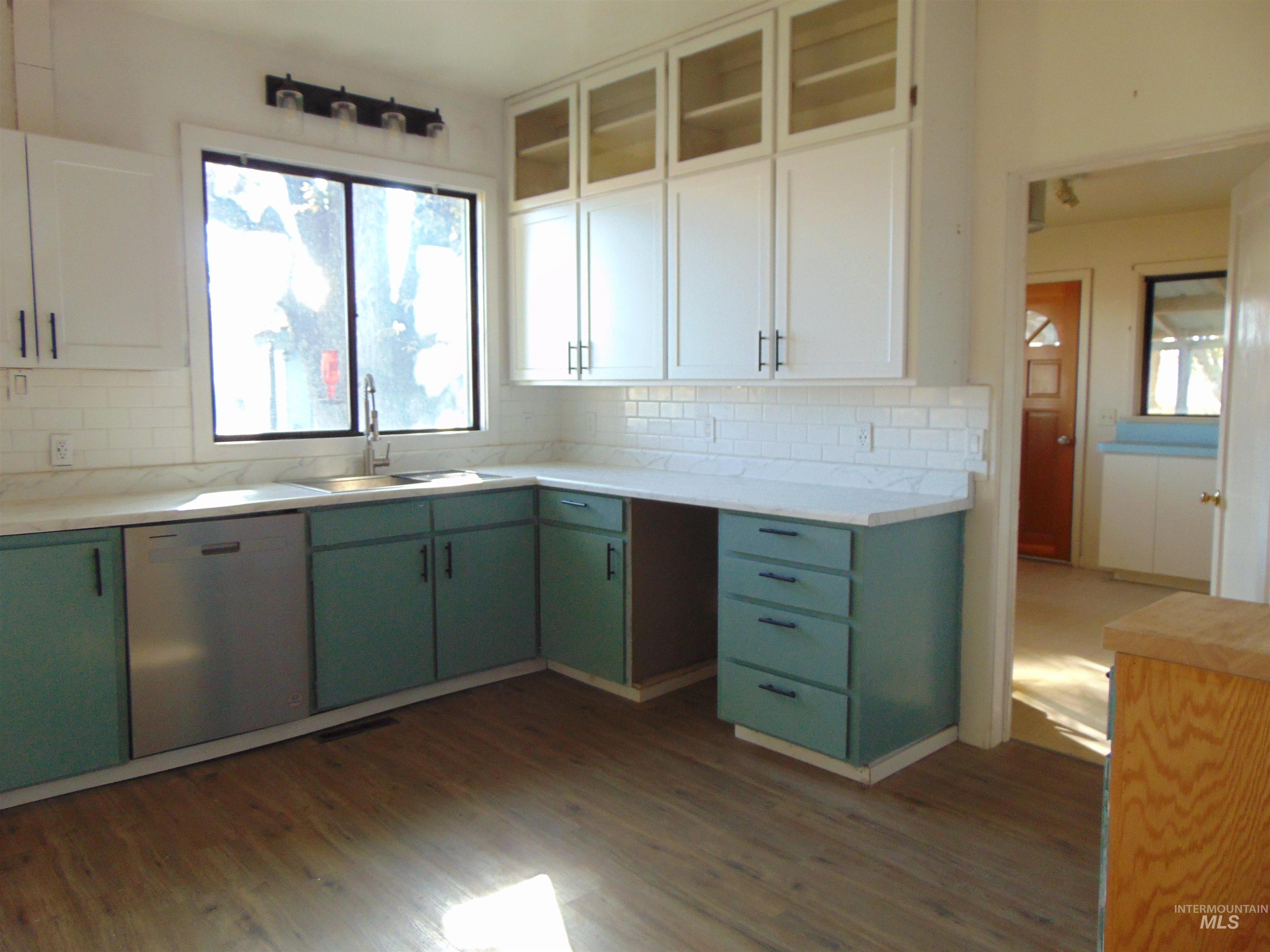 Kitchen featuring green cabinetry, white cabinets, dishwasher, and plenty of natural light