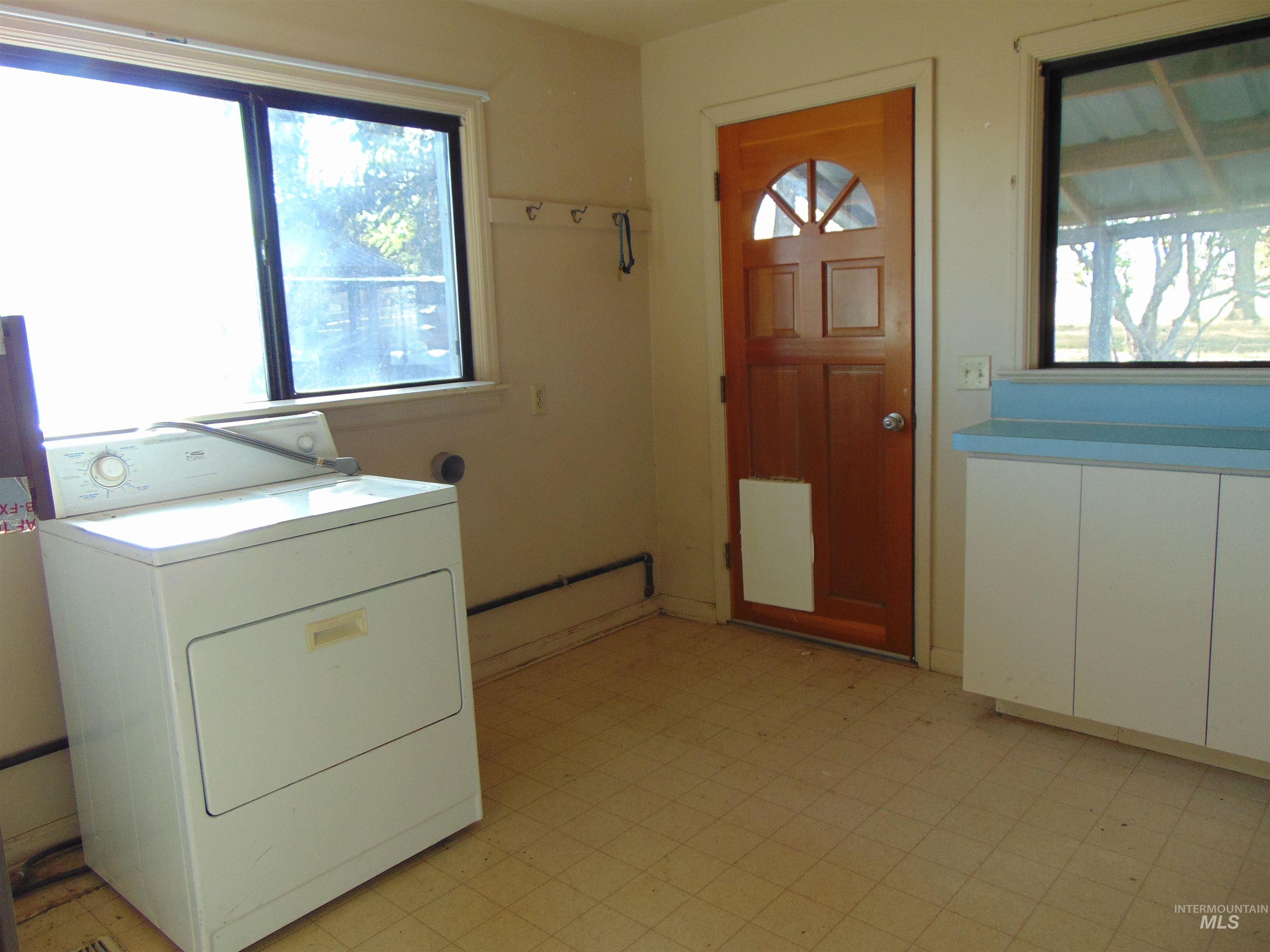 Laundry room with washer / dryer and light flooring