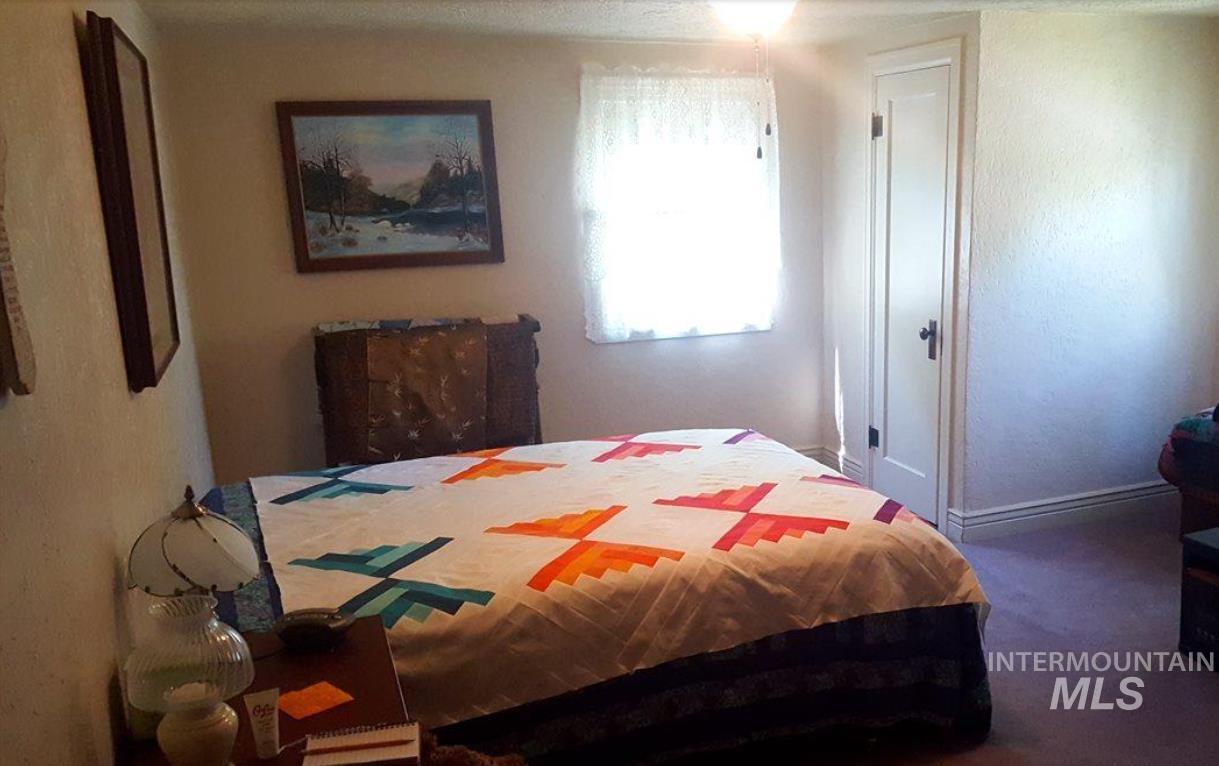 Carpeted bedroom with baseboards and a textured wall