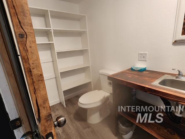 Half bathroom featuring light wood-style floors and toilet