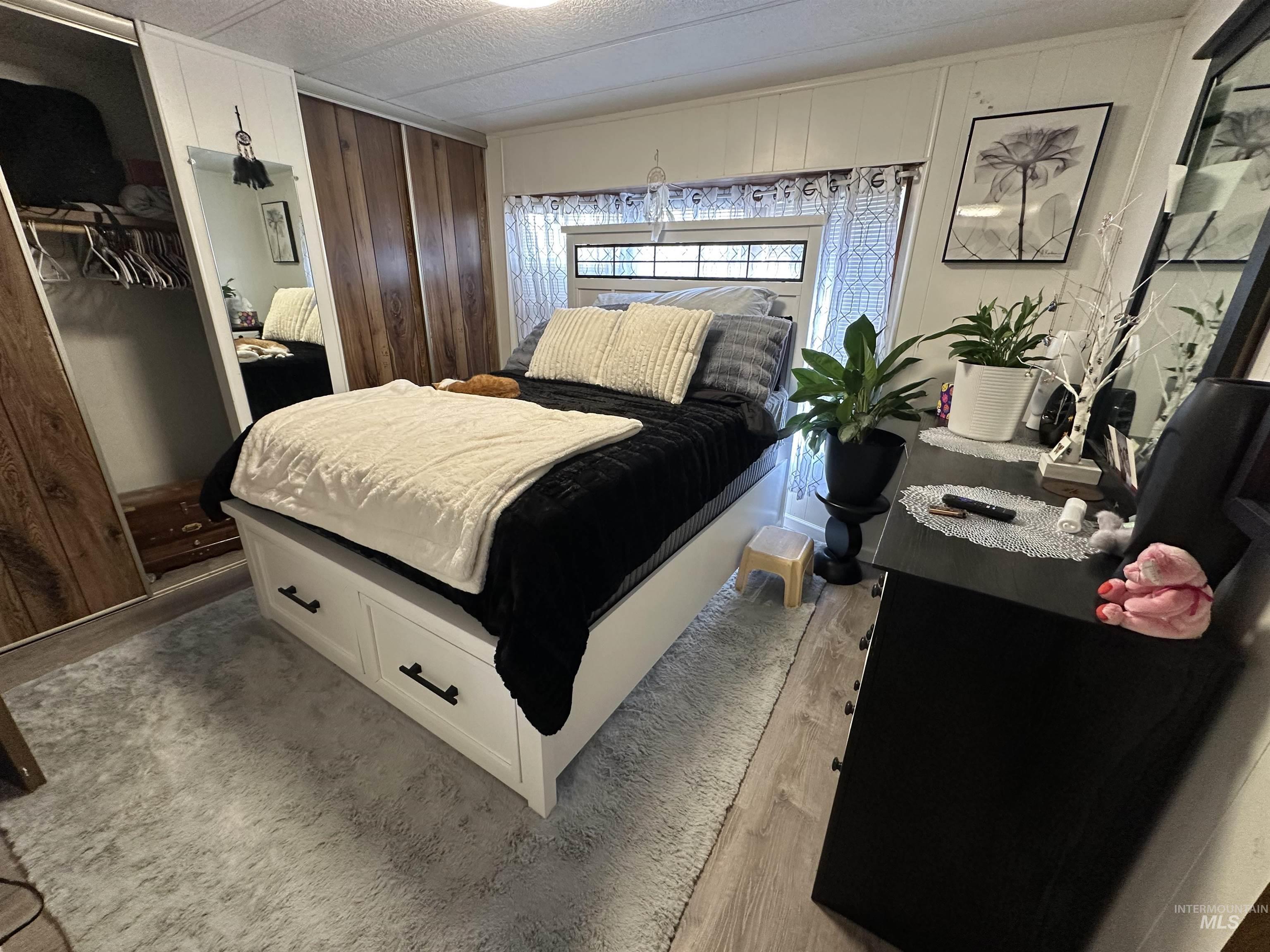 Bedroom featuring wooden walls and light wood finished floors