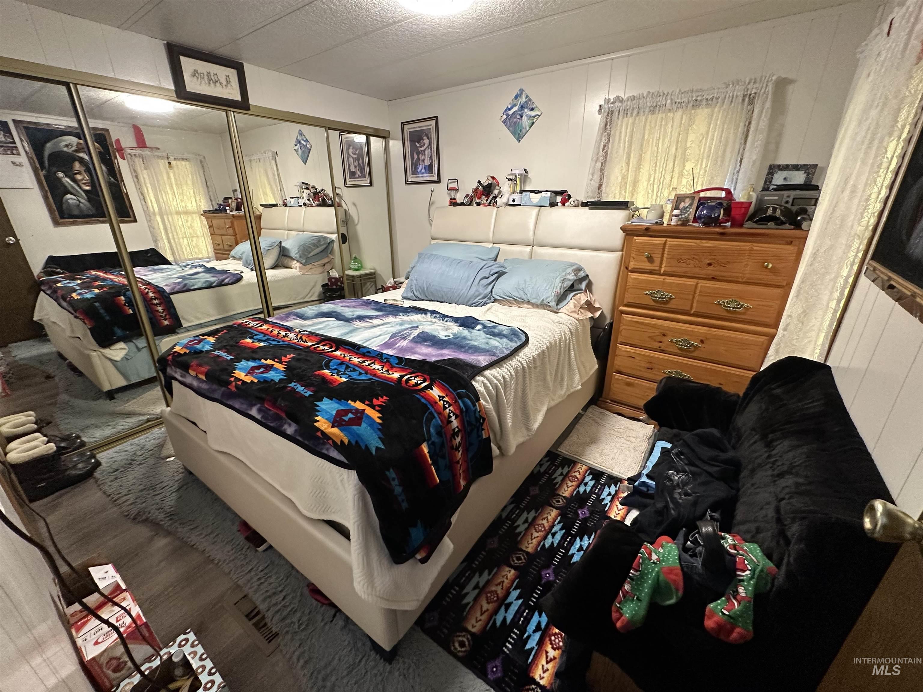Bedroom featuring a closet, wood finished floors, and wooden walls