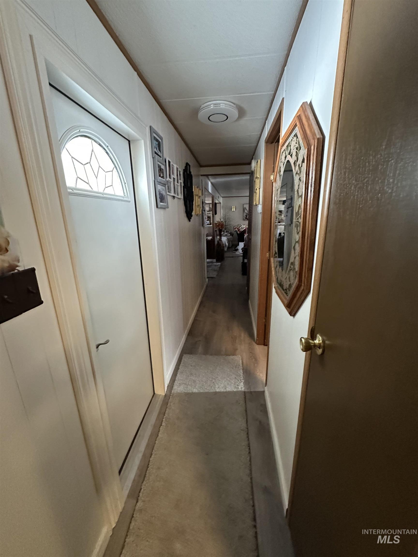 Hall featuring baseboards and concrete flooring