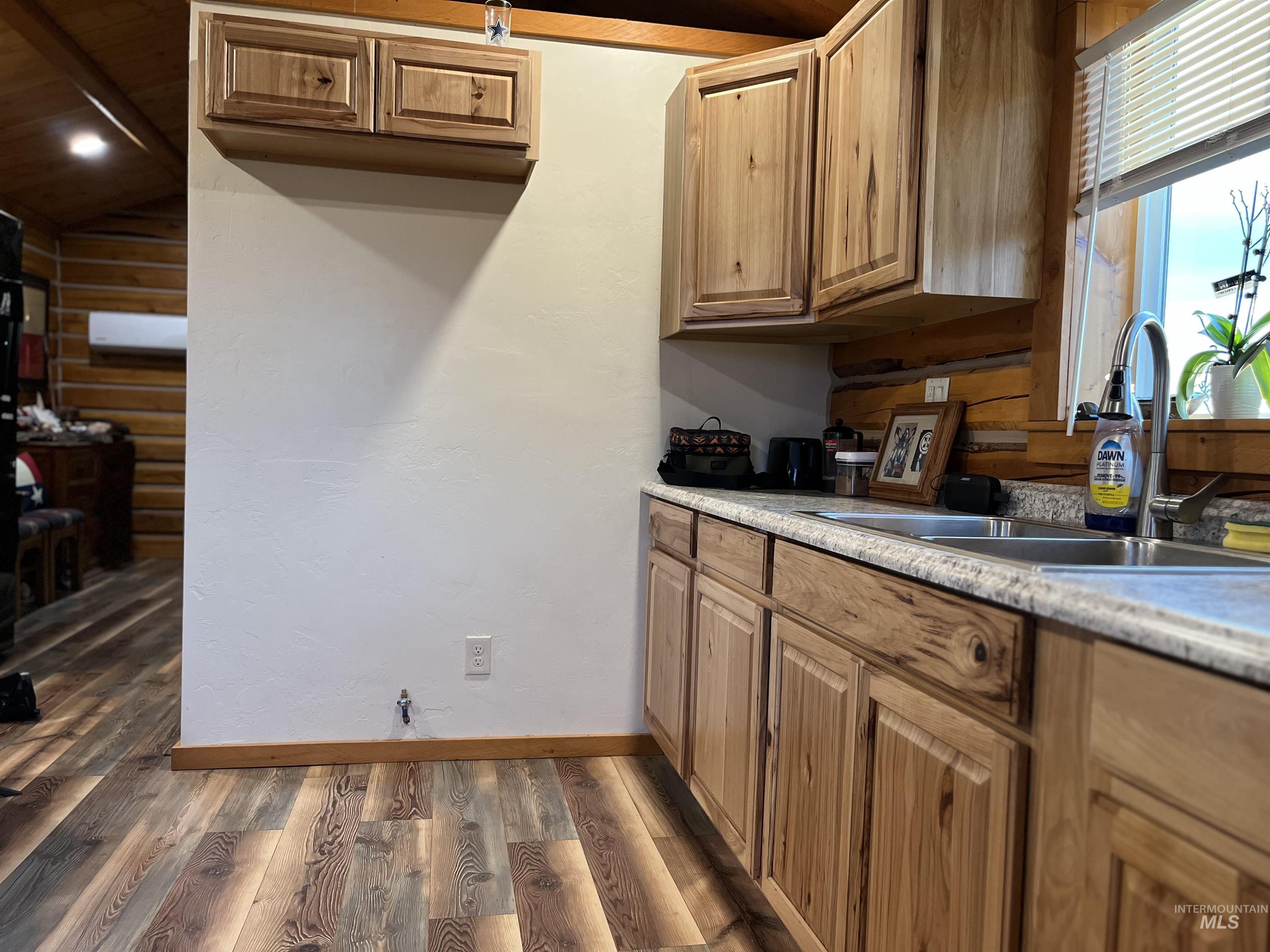 Kitchen with dark wood-type flooring, light countertops, and brown cabinetry