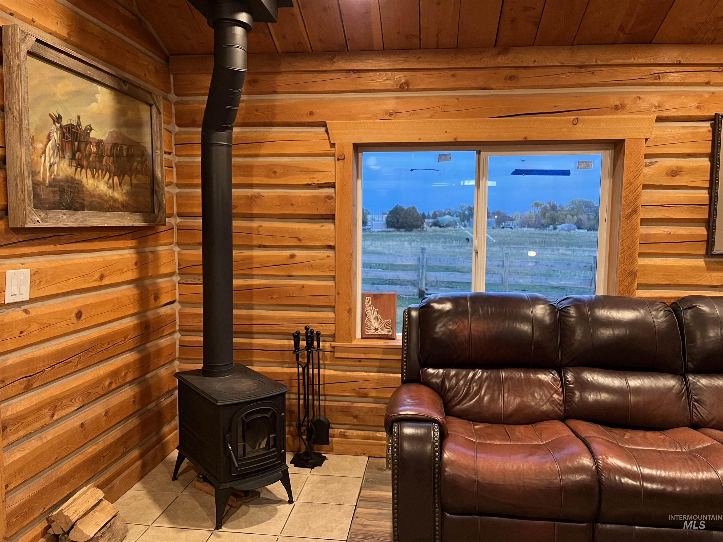Tiled living room with a wood stove, rustic walls, and wood ceiling