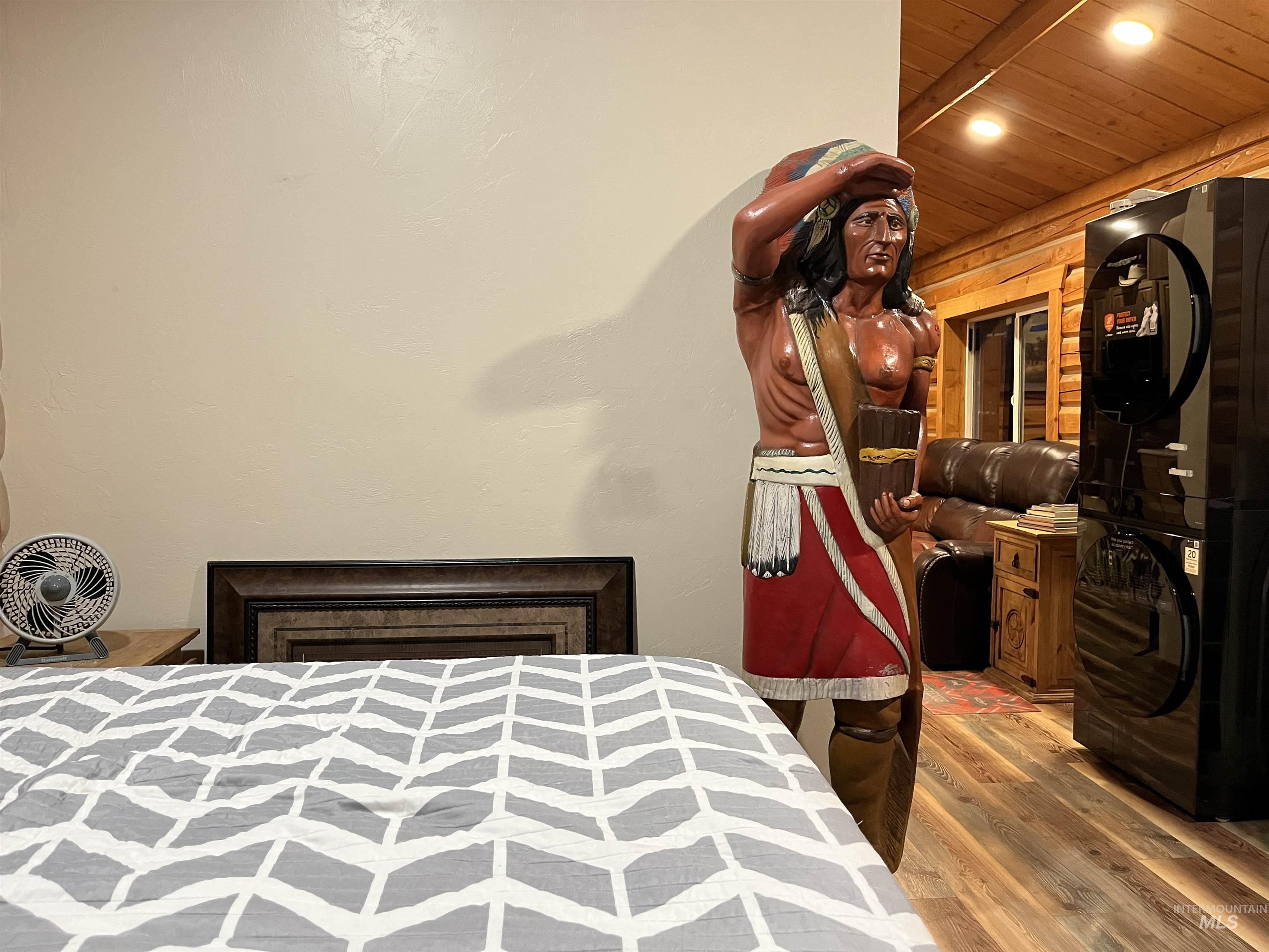 Bedroom featuring wood finished floors, recessed lighting, and stacked washer / dryer