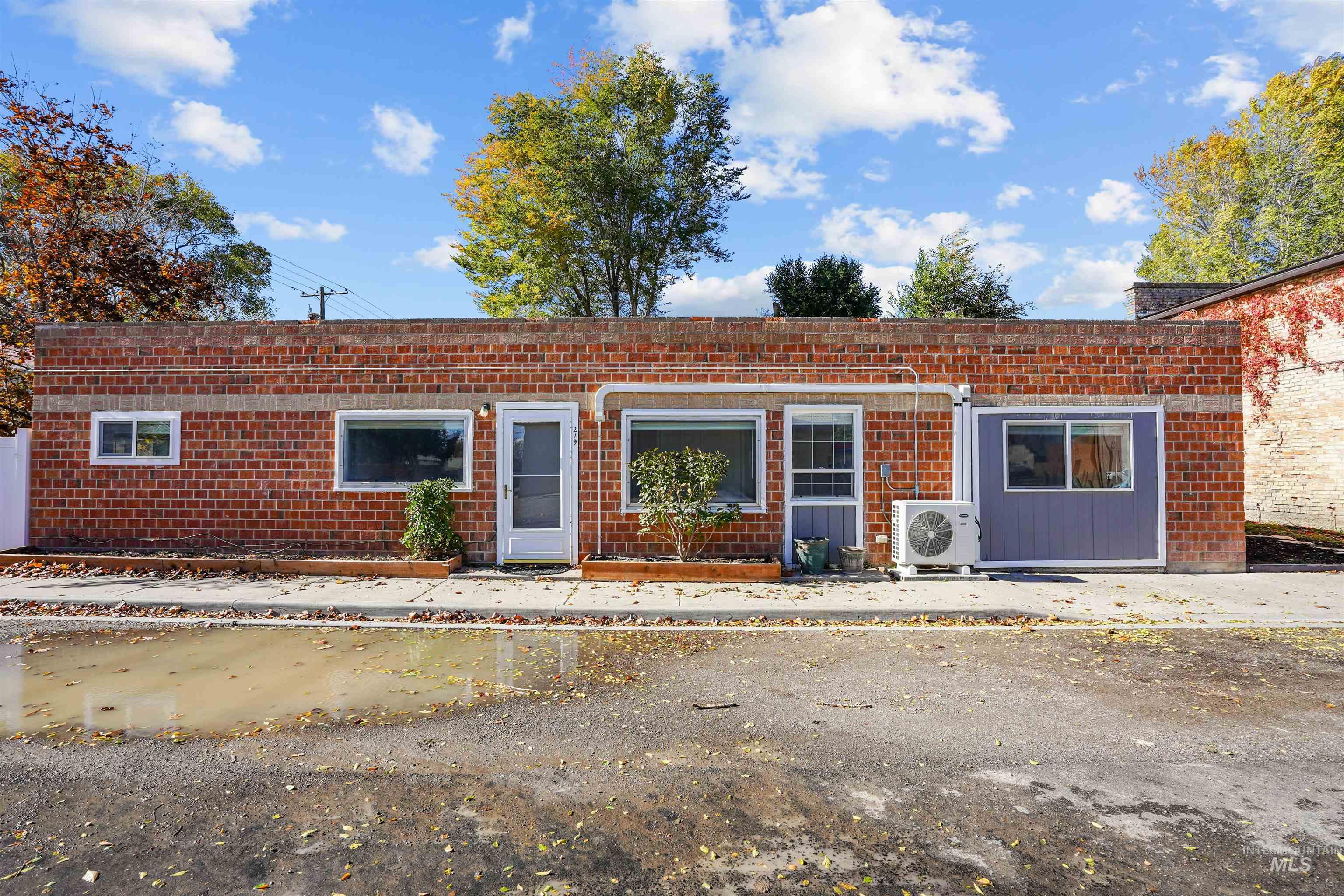 View of front of house with a patio area and brick siding