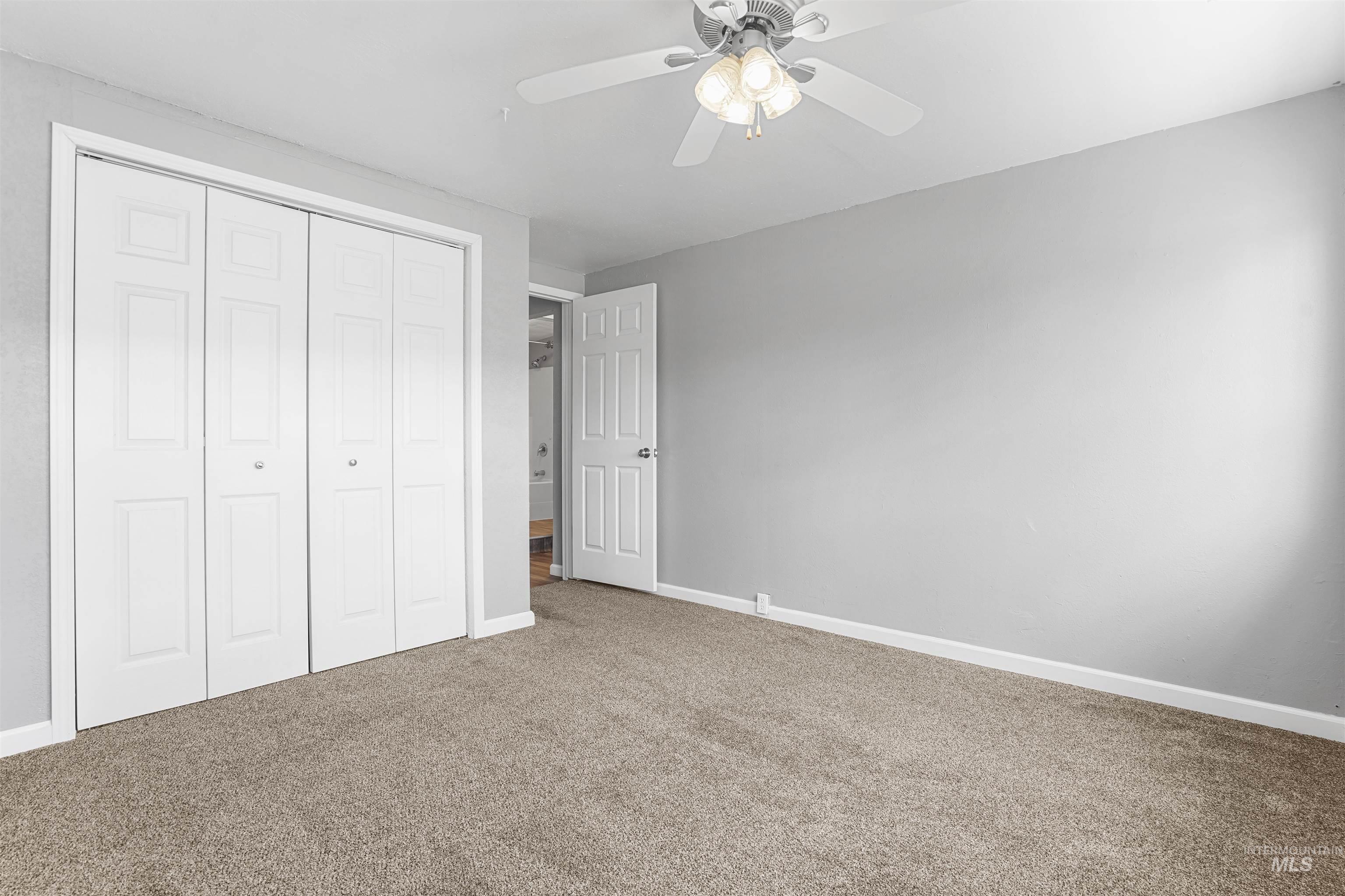 Unfurnished bedroom with carpet flooring, a closet, and ceiling fan