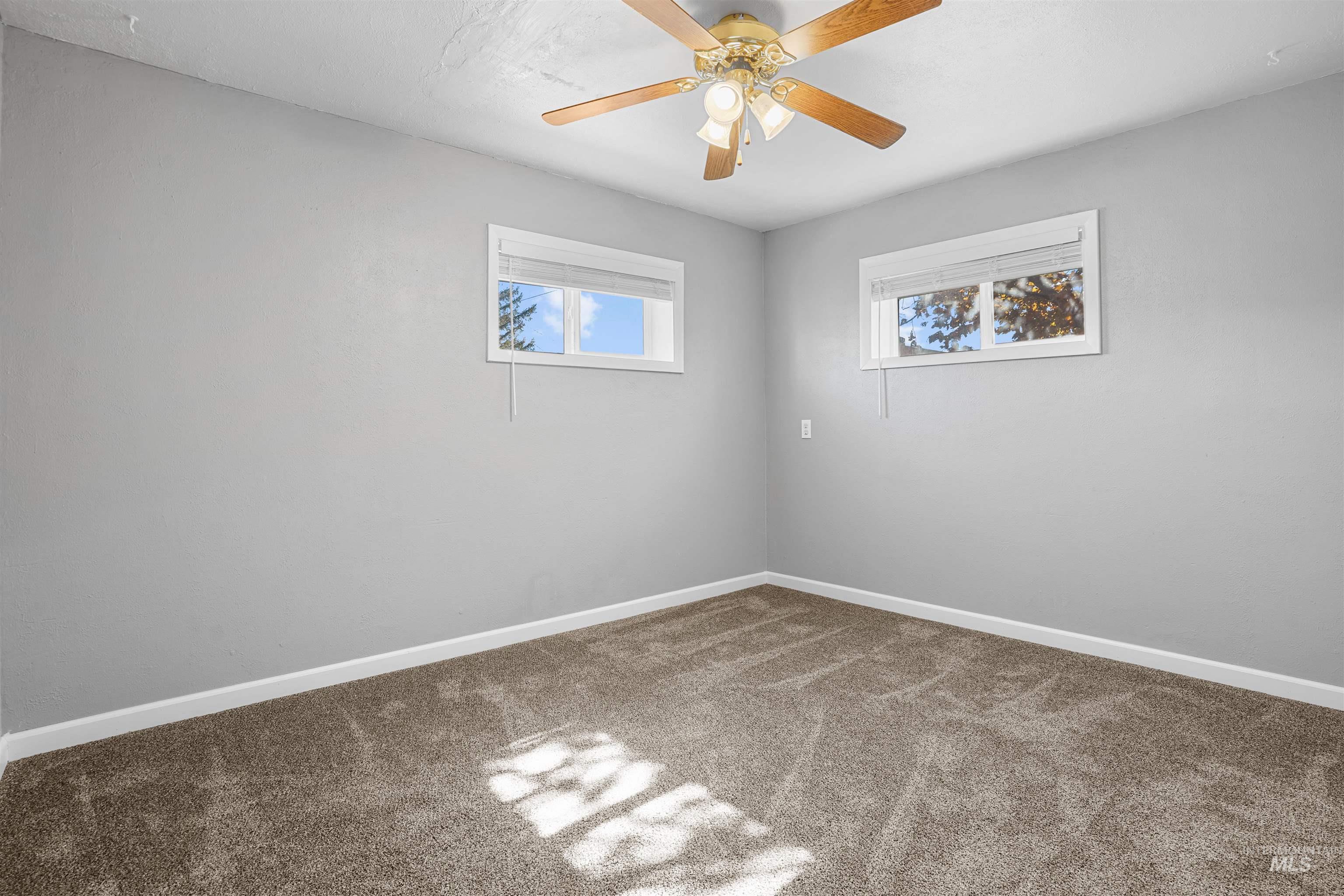 Empty room with carpet and a ceiling fan