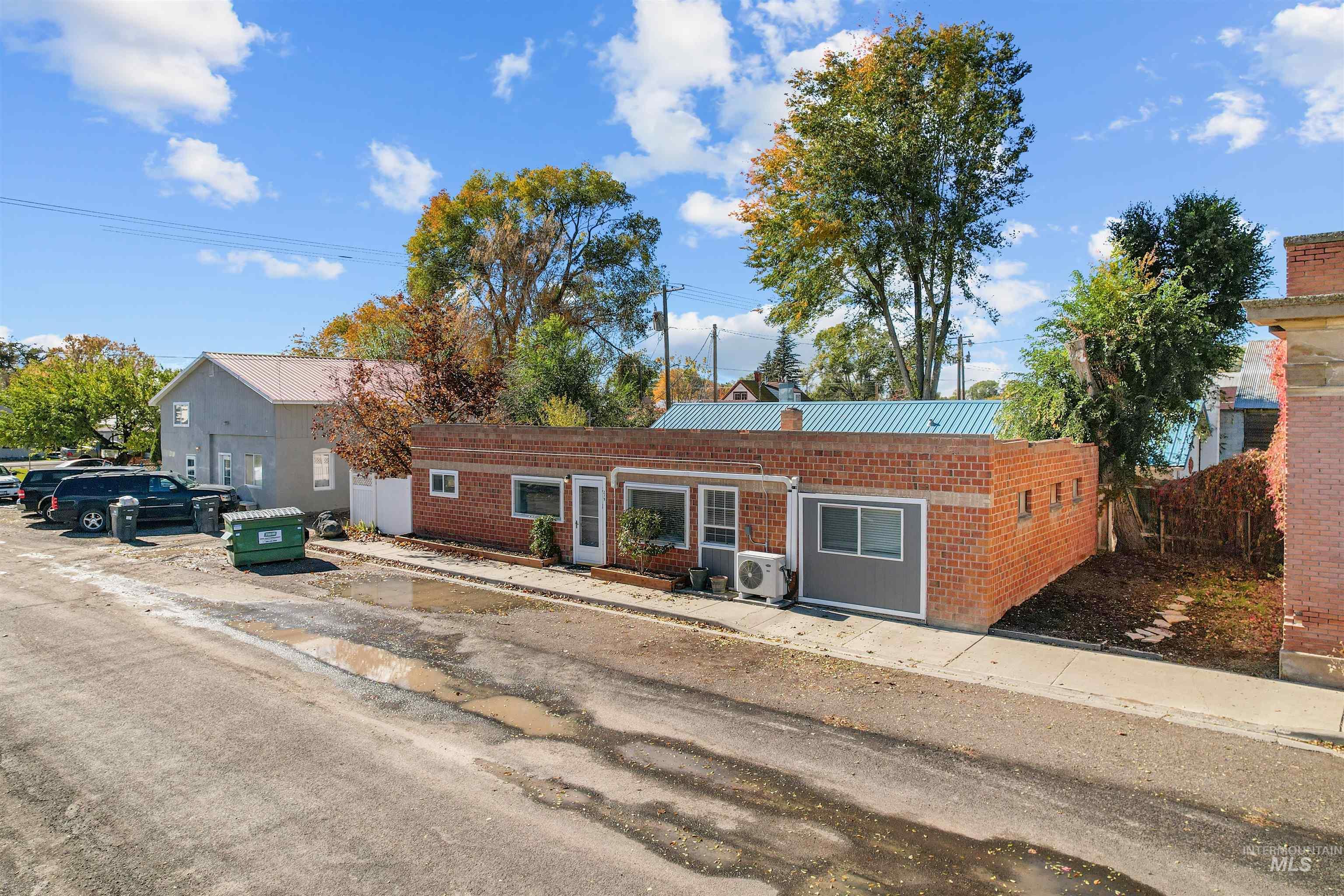View of front facade featuring brick siding and a metal roof