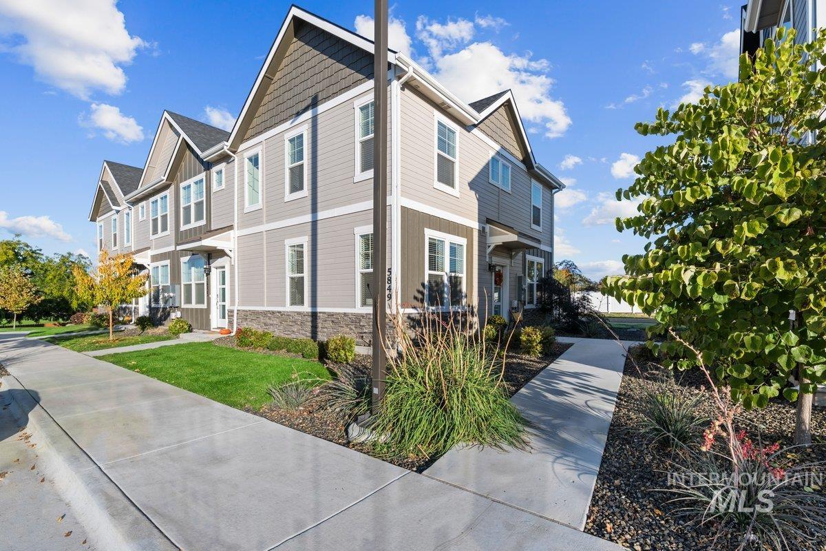 View of side of home featuring stone siding and a yard