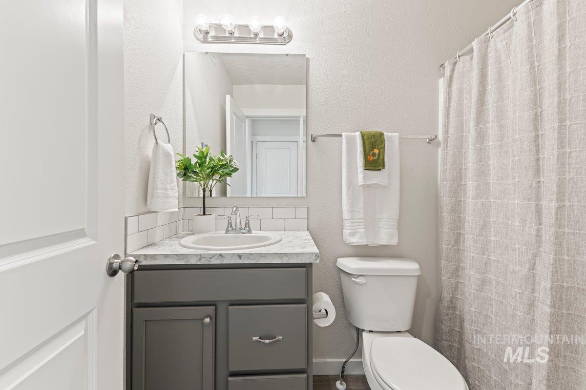Bathroom featuring a shower with curtain, vanity, and a textured wall