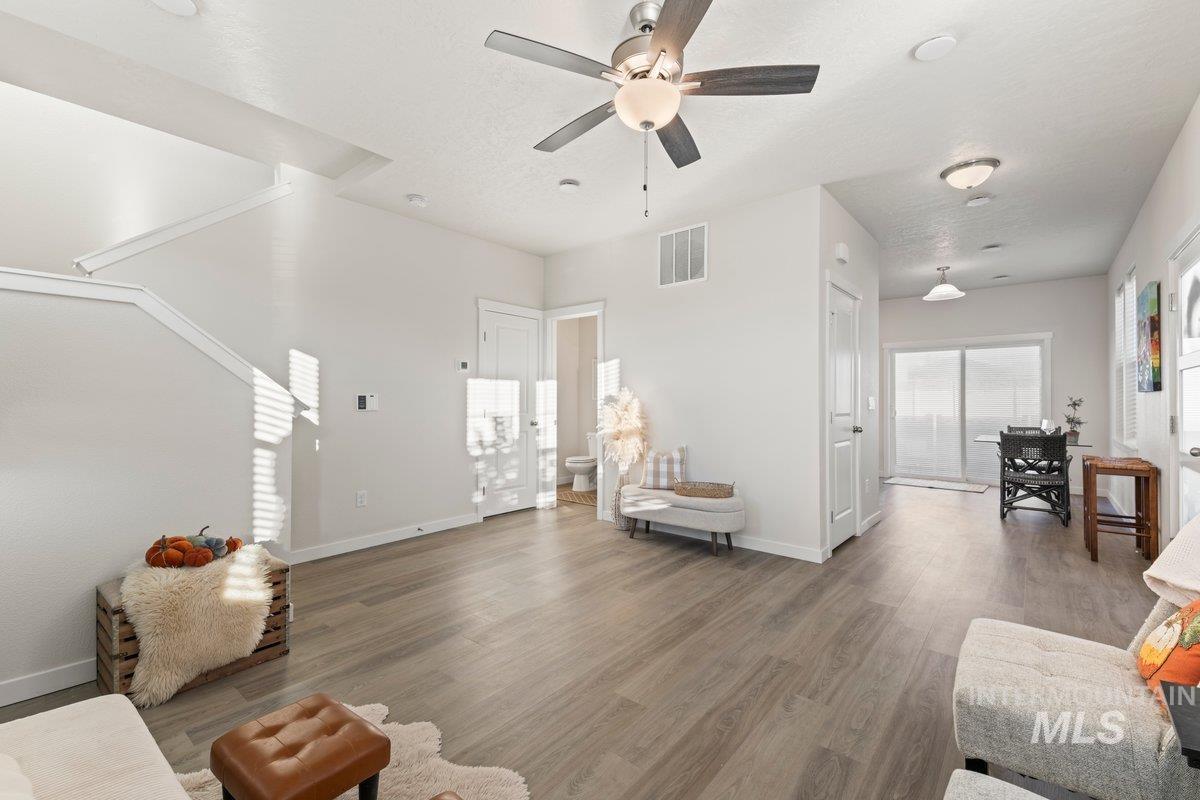 Living area with light wood finished floors and ceiling fan