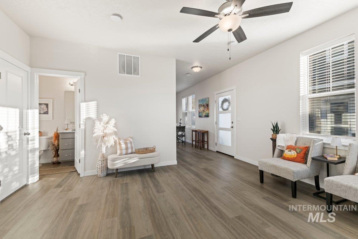 Living area featuring light wood finished floors and ceiling fan