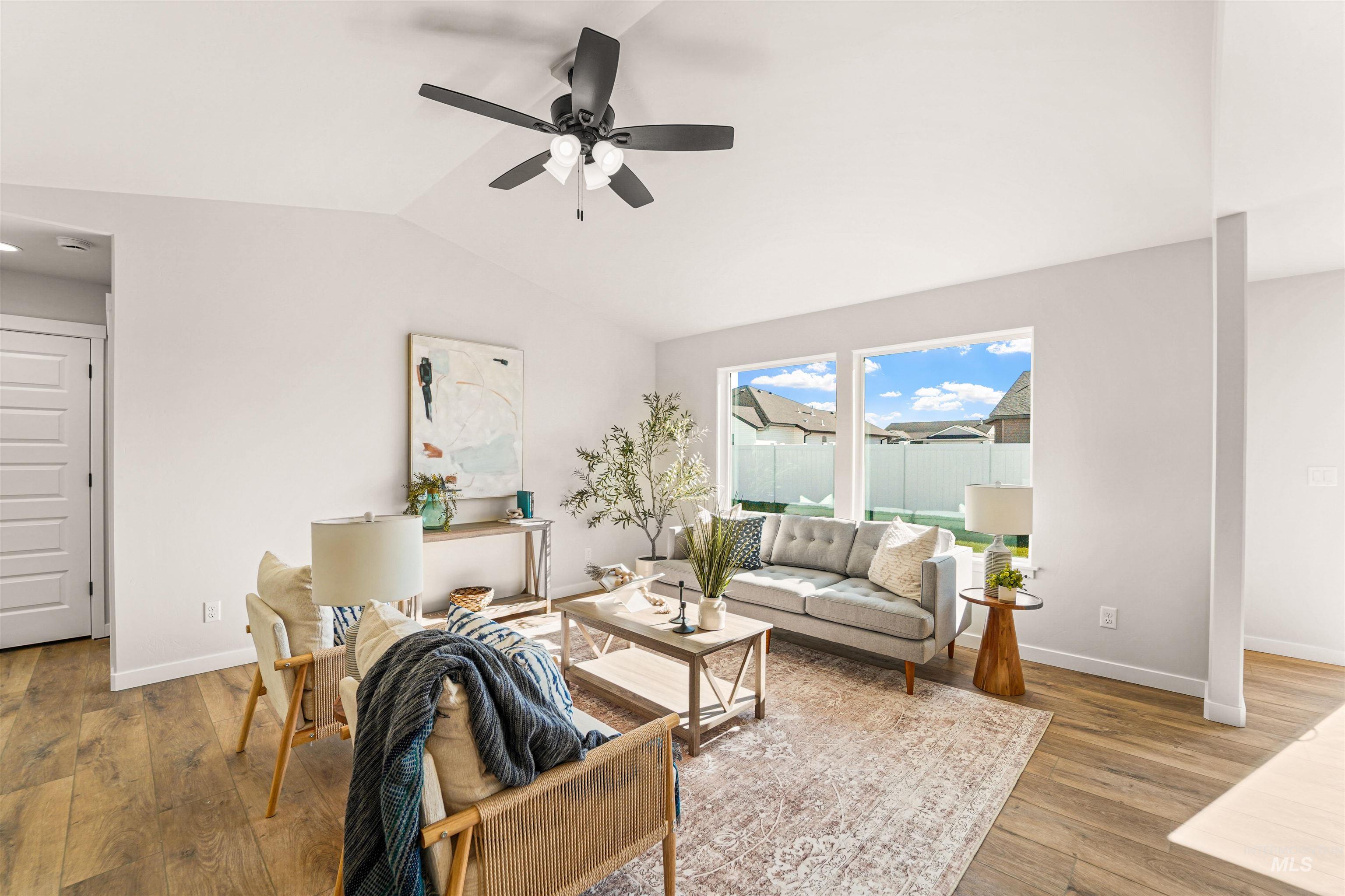 Living area with lofted ceiling, wood finished floors, and a ceiling fan