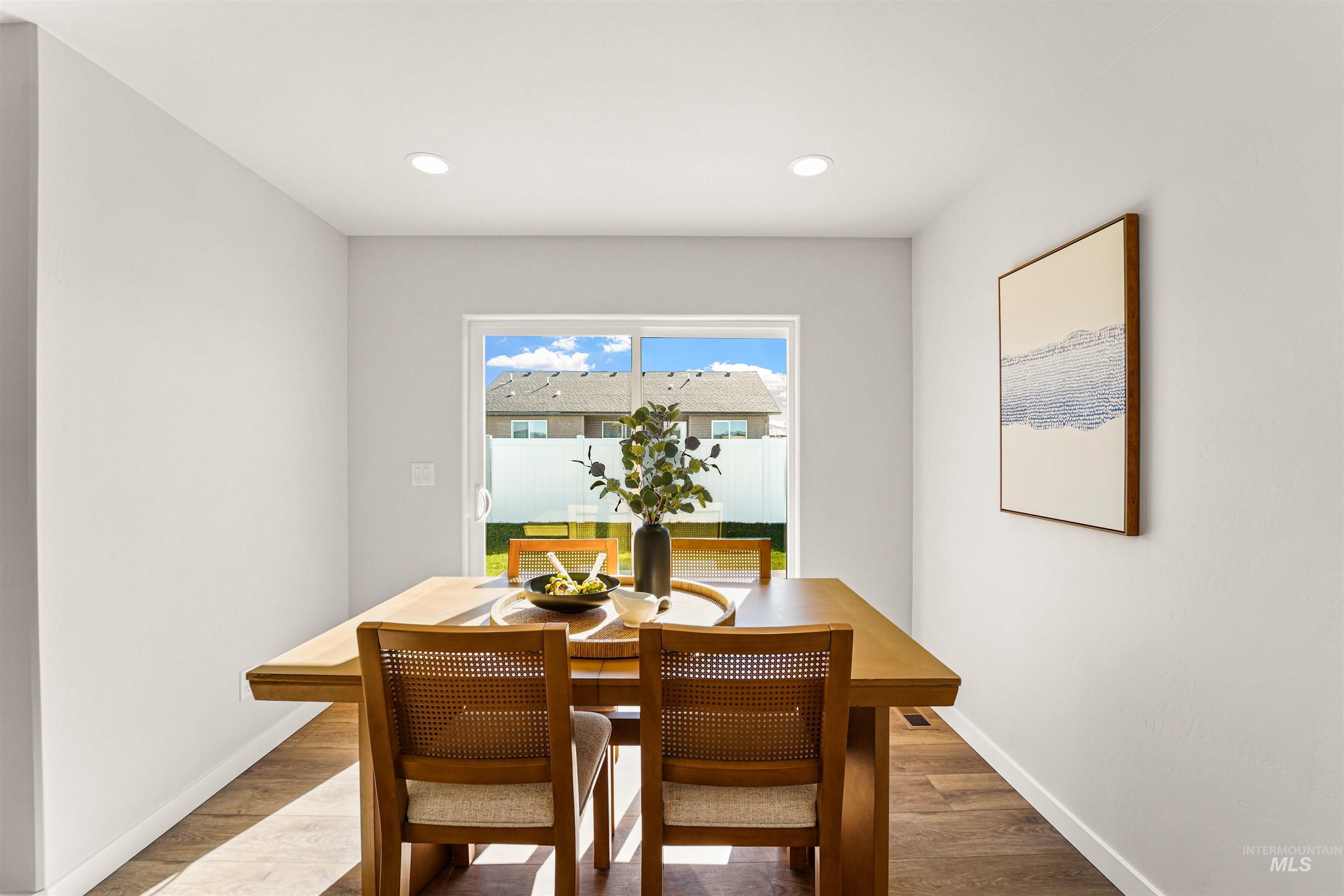 Dining space with wood finished floors and recessed lighting