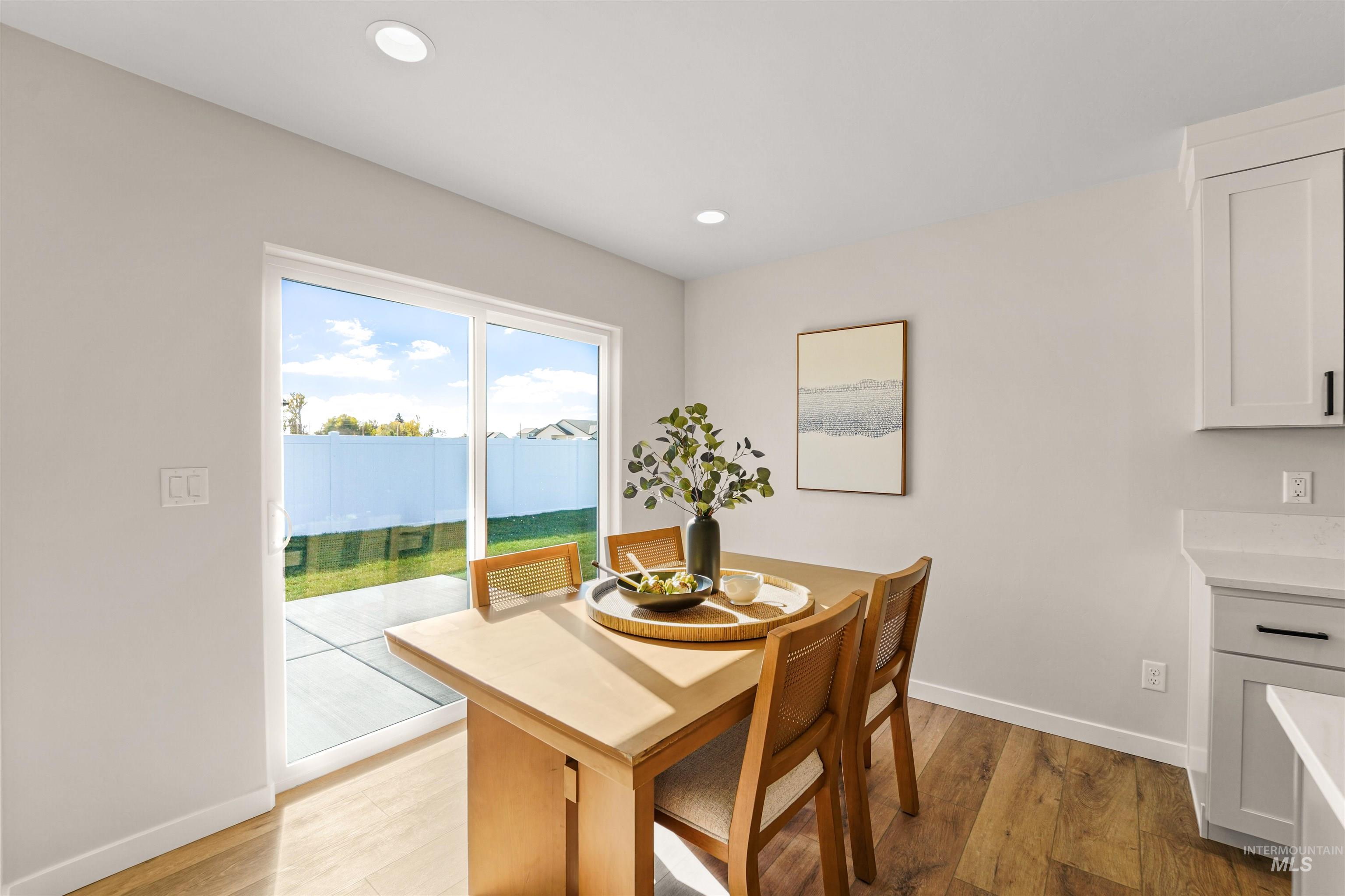 Dining area with light wood-style floors and recessed lighting