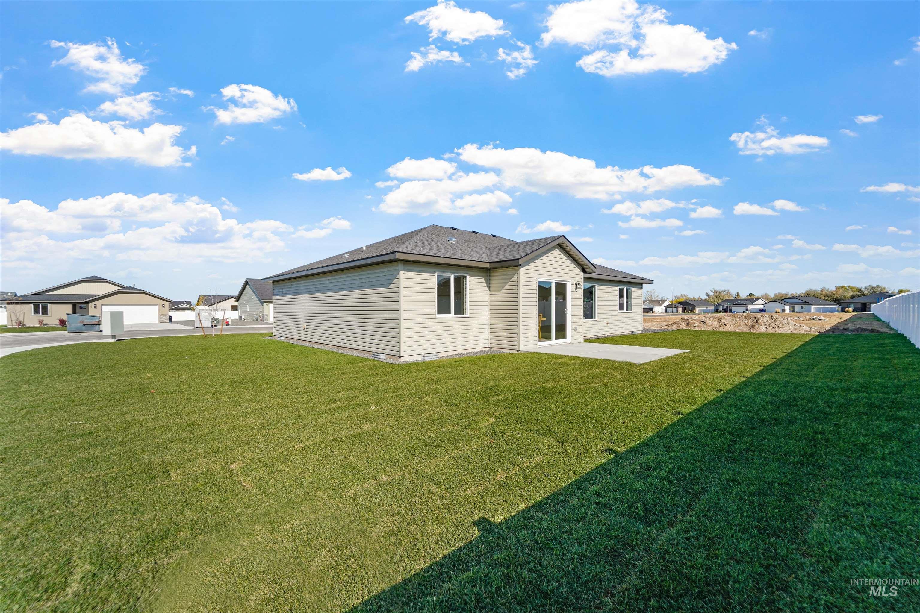 Back of house featuring a patio area, a lawn, and a residential view