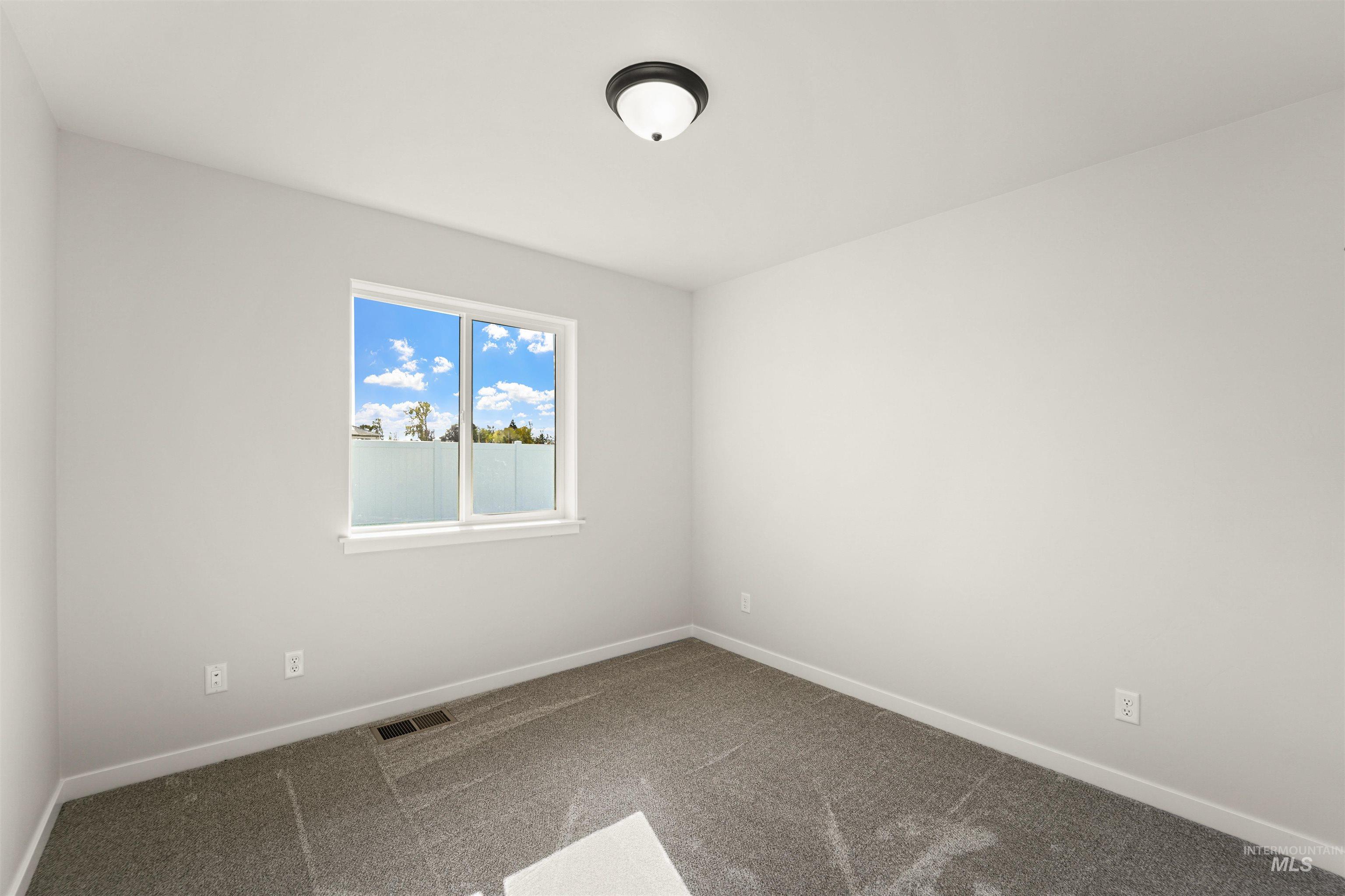 Carpeted spare room with baseboards