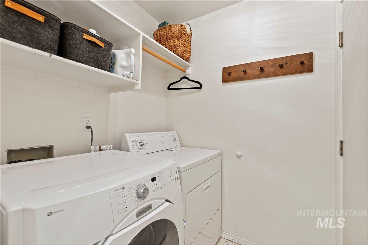 Washroom featuring independent washer and dryer and baseboards