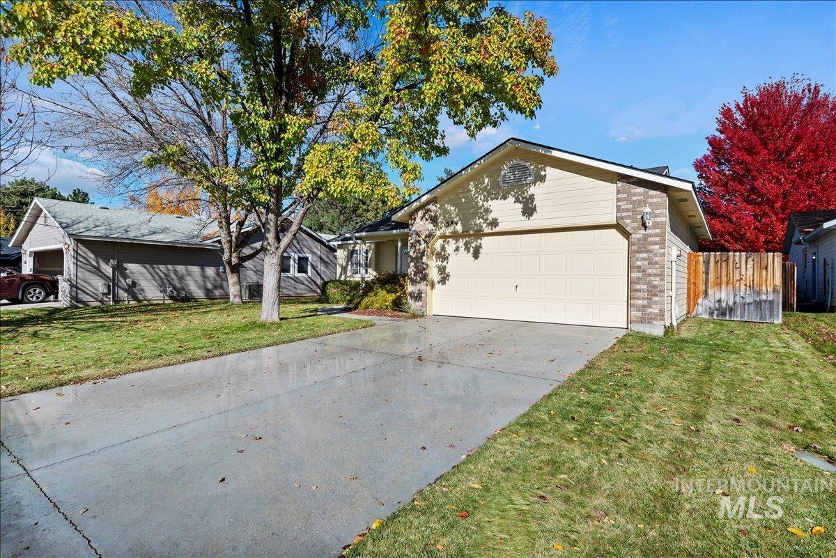 Ranch-style home with concrete driveway, brick siding, and an attached garage