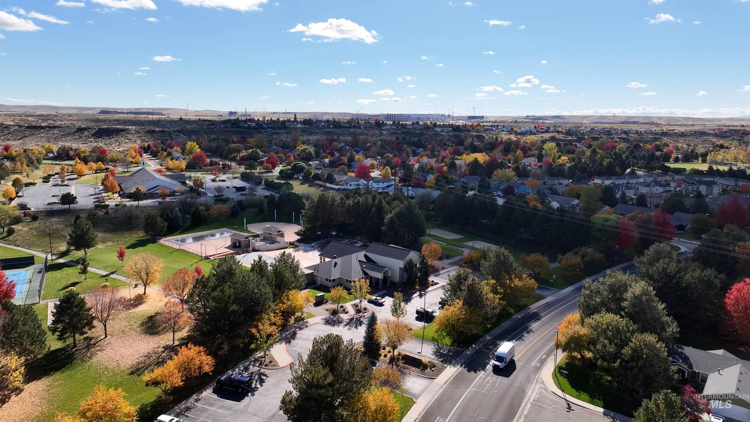 Aerial view of property and surrounding area with nearby suburban area