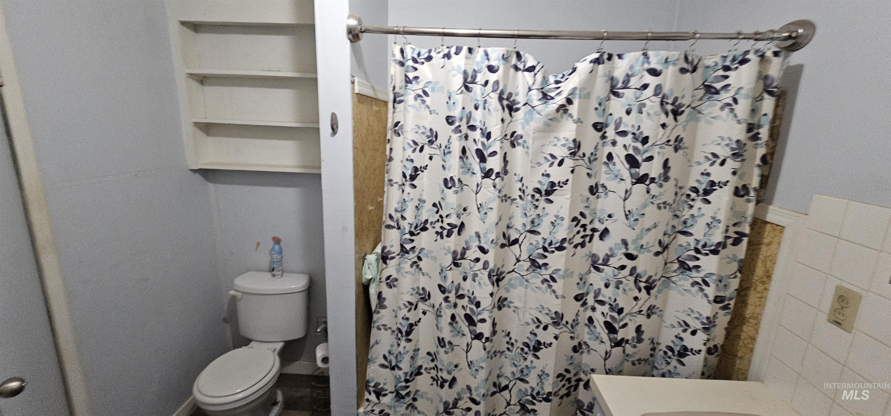 Full bath featuring a shower with shower curtain, tile walls, and vanity