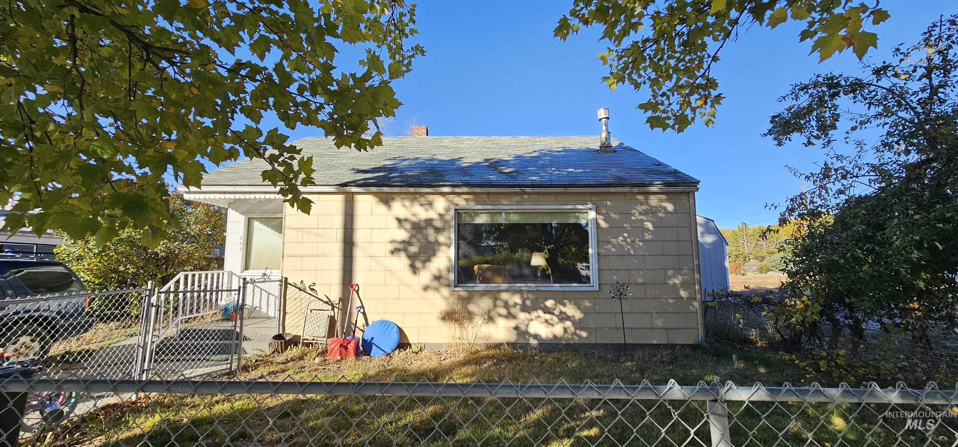 View of property exterior featuring a chimney and a shingled roof