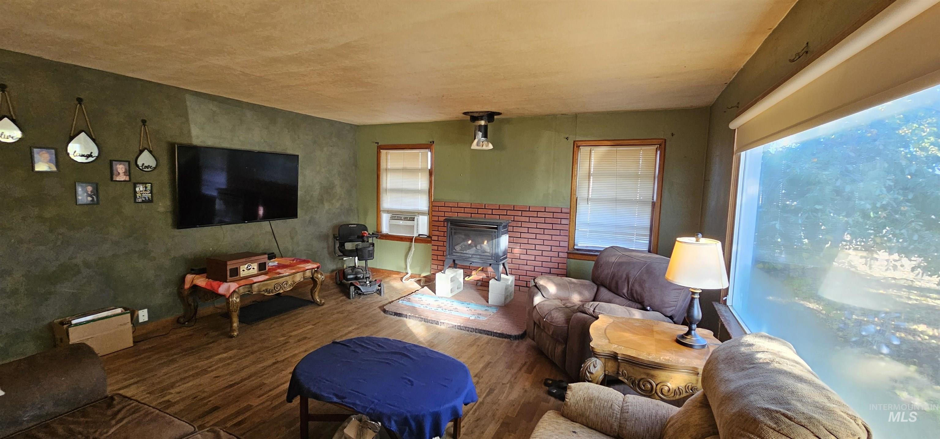Living area featuring wood finished floors, healthy amount of natural light, and a fireplace