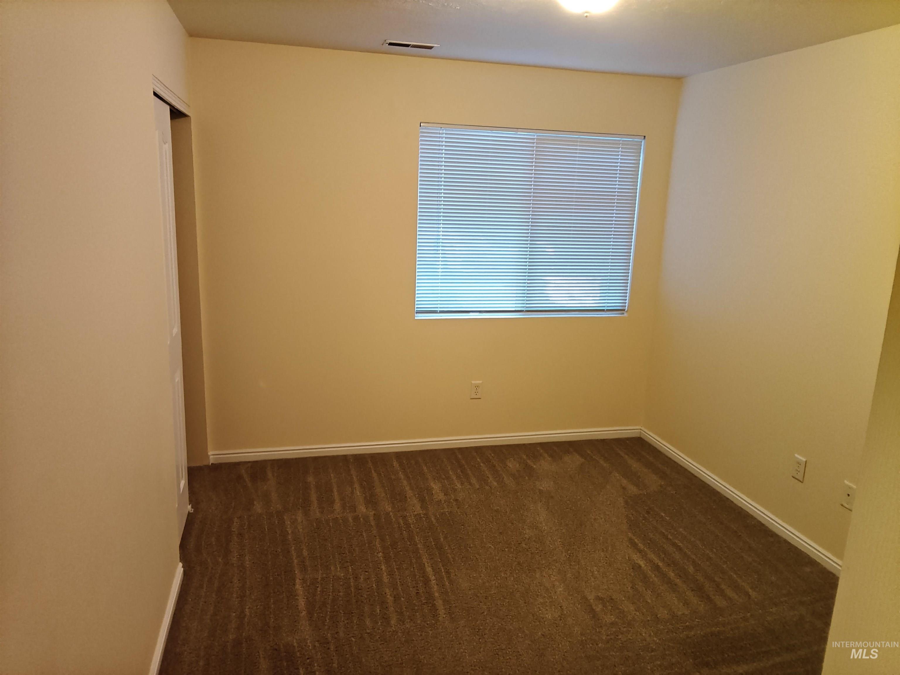 Unfurnished room with dark carpet