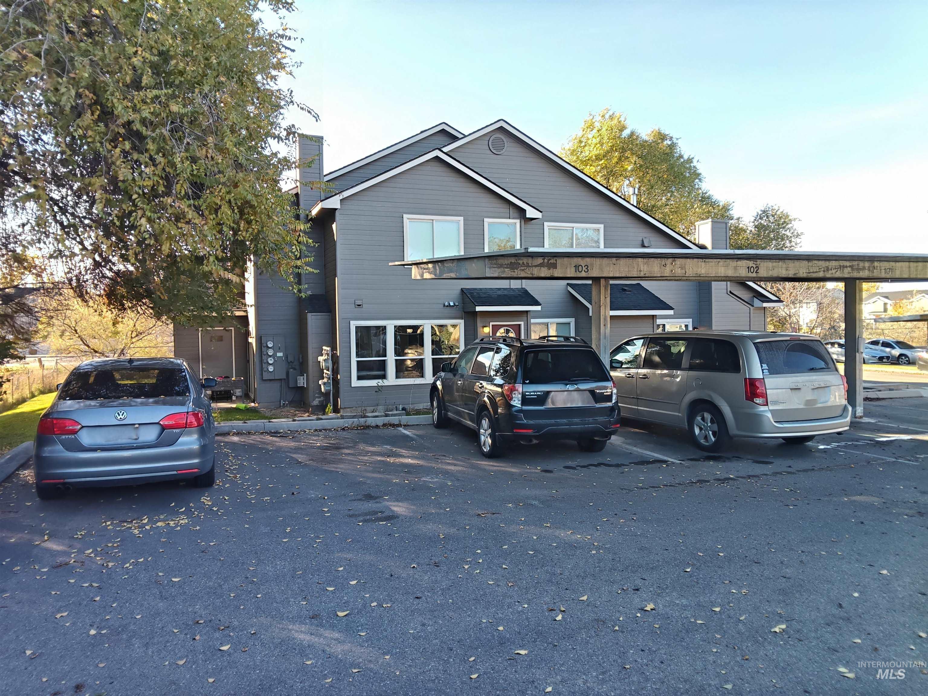 Traditional-style home with covered and uncovered parking and a chimney
