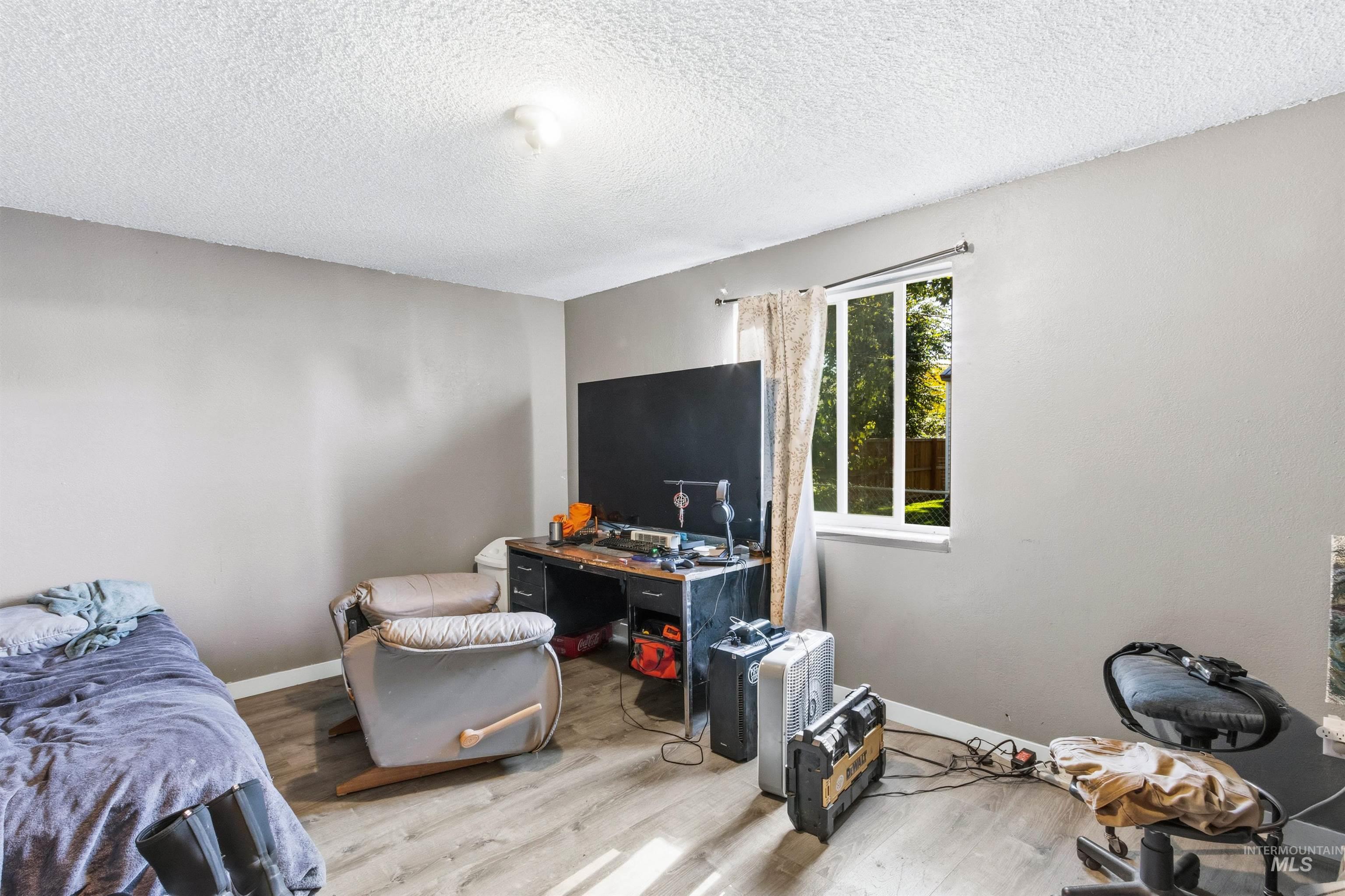Bedroom featuring wood finished floors and a textured ceiling