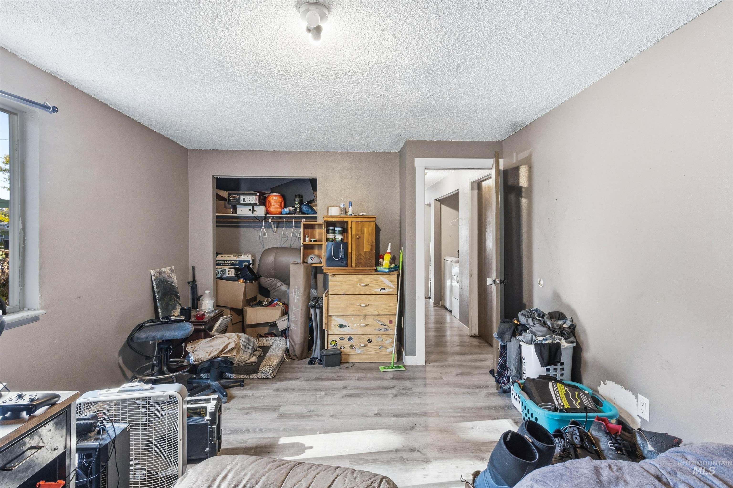 Bedroom featuring wood finished floors, a closet, and a textured ceiling