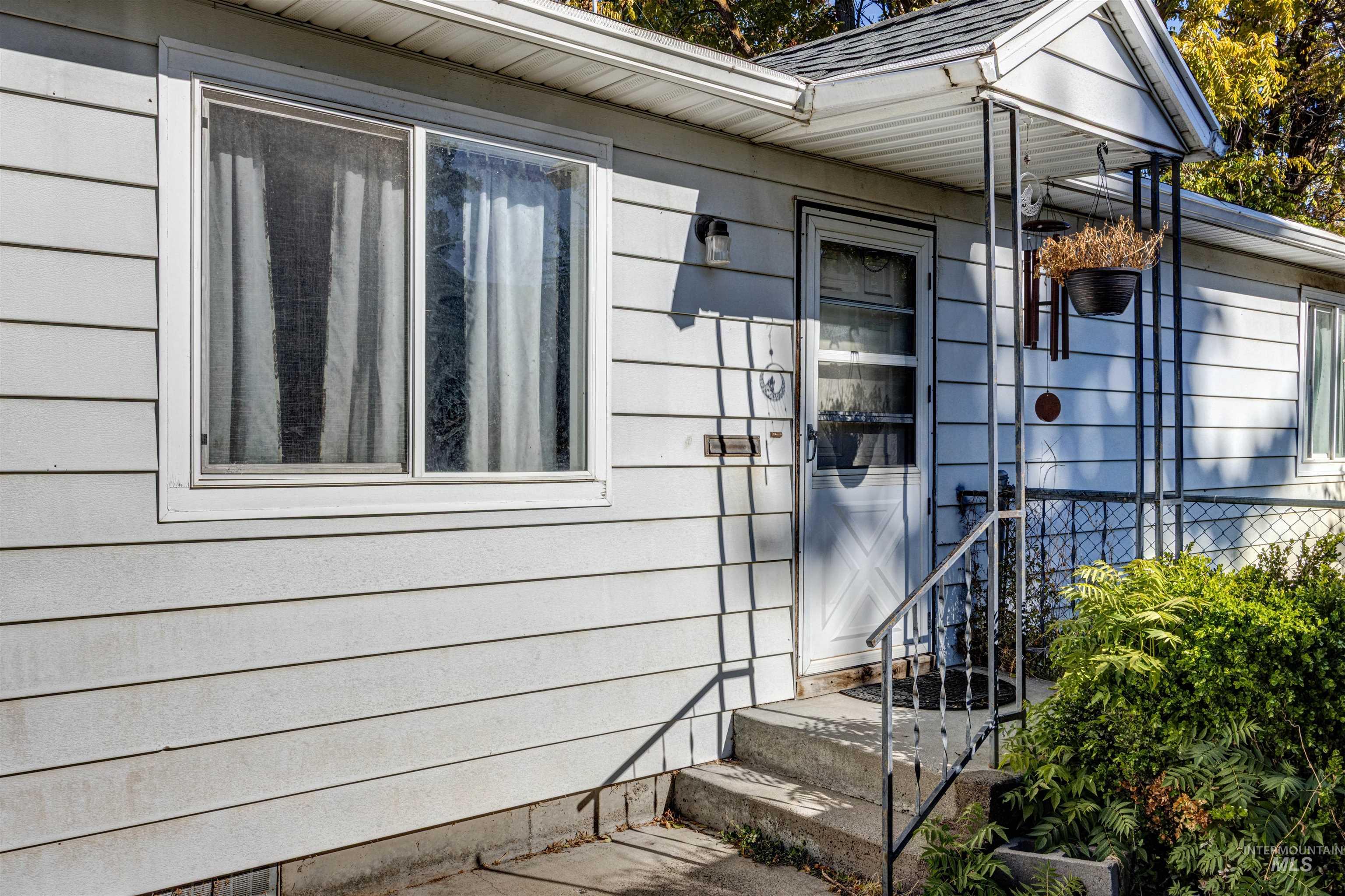 Doorway to property with roof with shingles