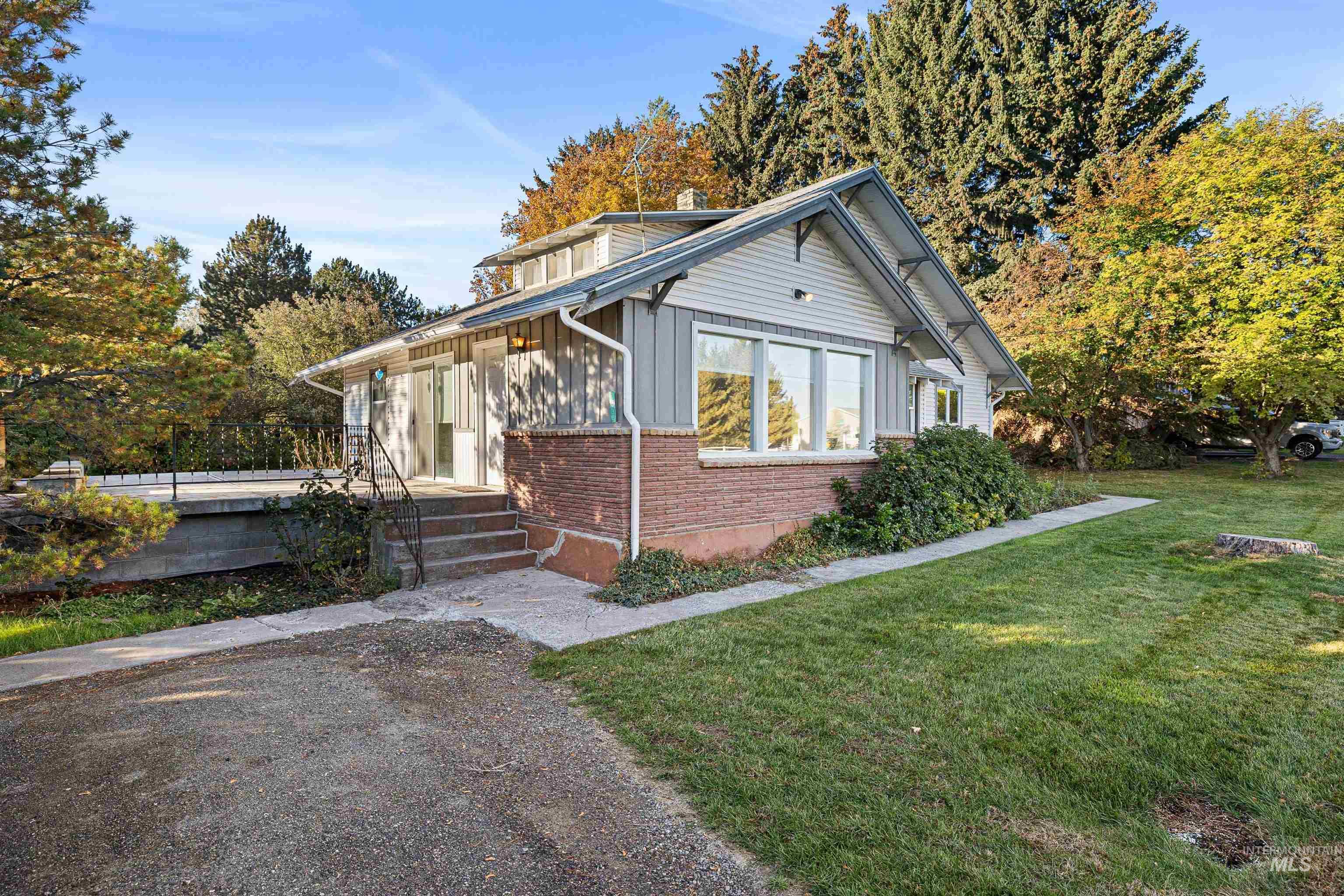 View of front of house featuring brick siding, a front yard, and a chimney