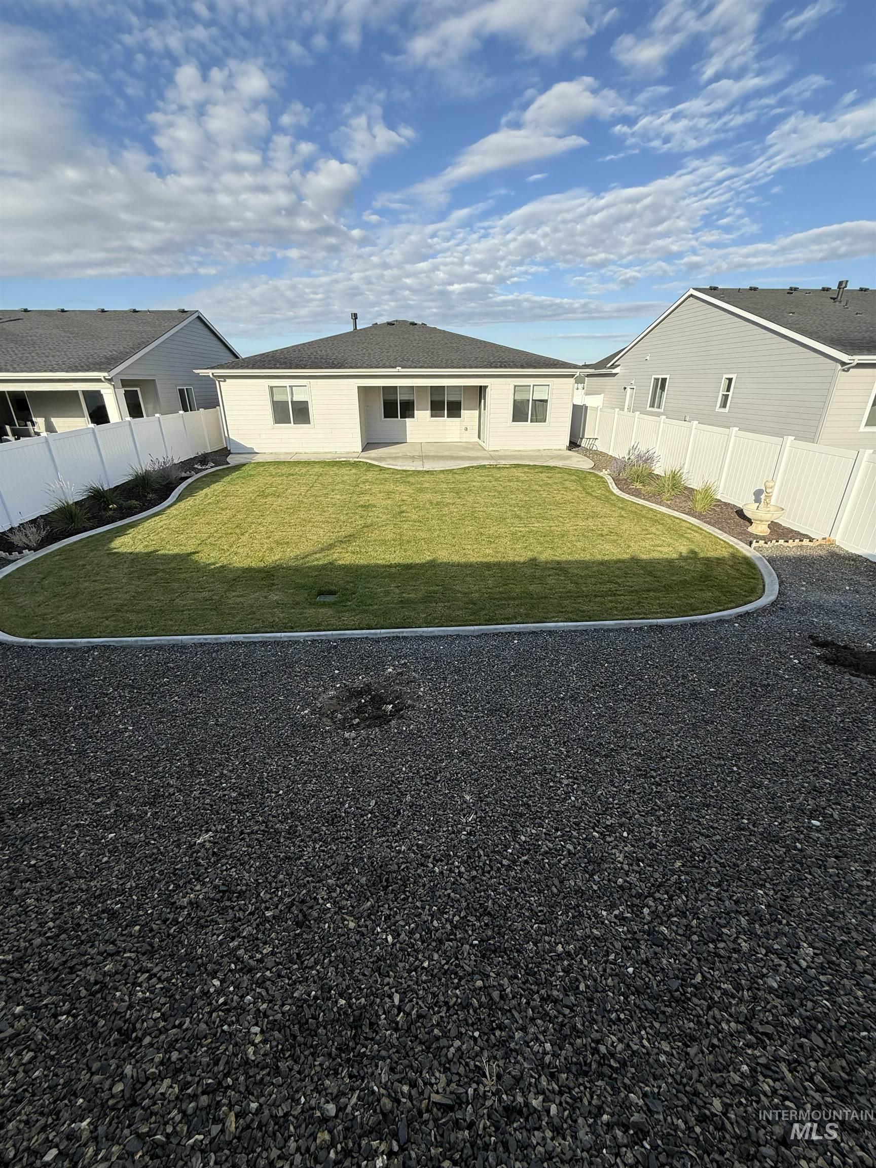 landscaped backyard with a patio area and a fenced                                           yard