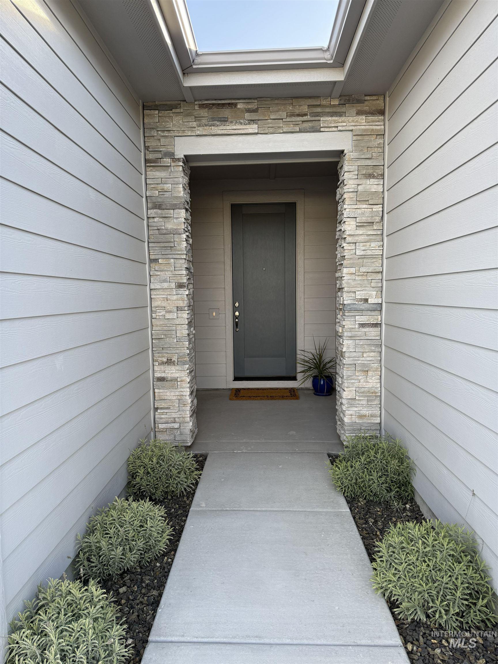 Doorway to property with stone siding and brick siding