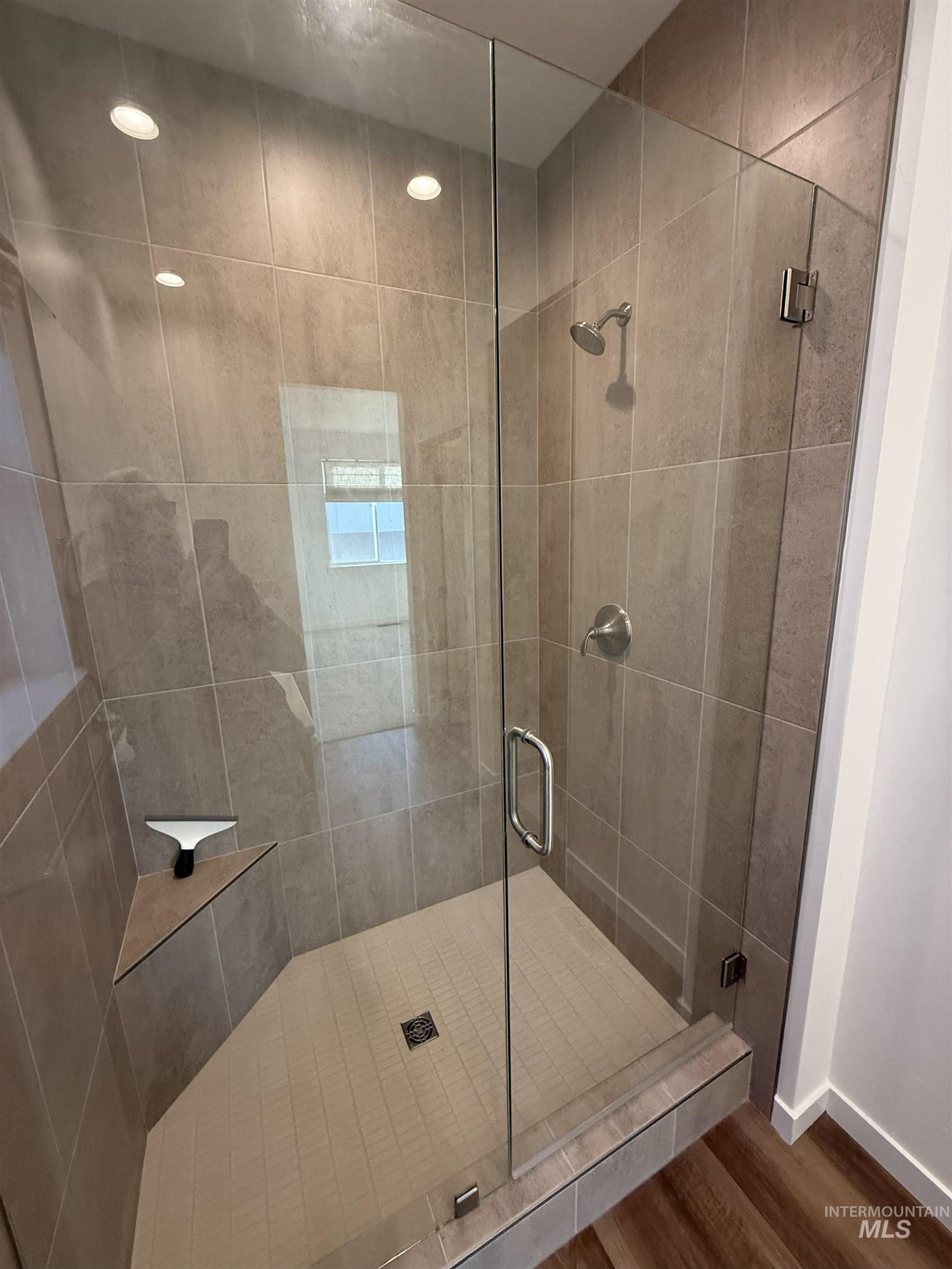 Full bathroom featuring a stall shower and wood finished floors