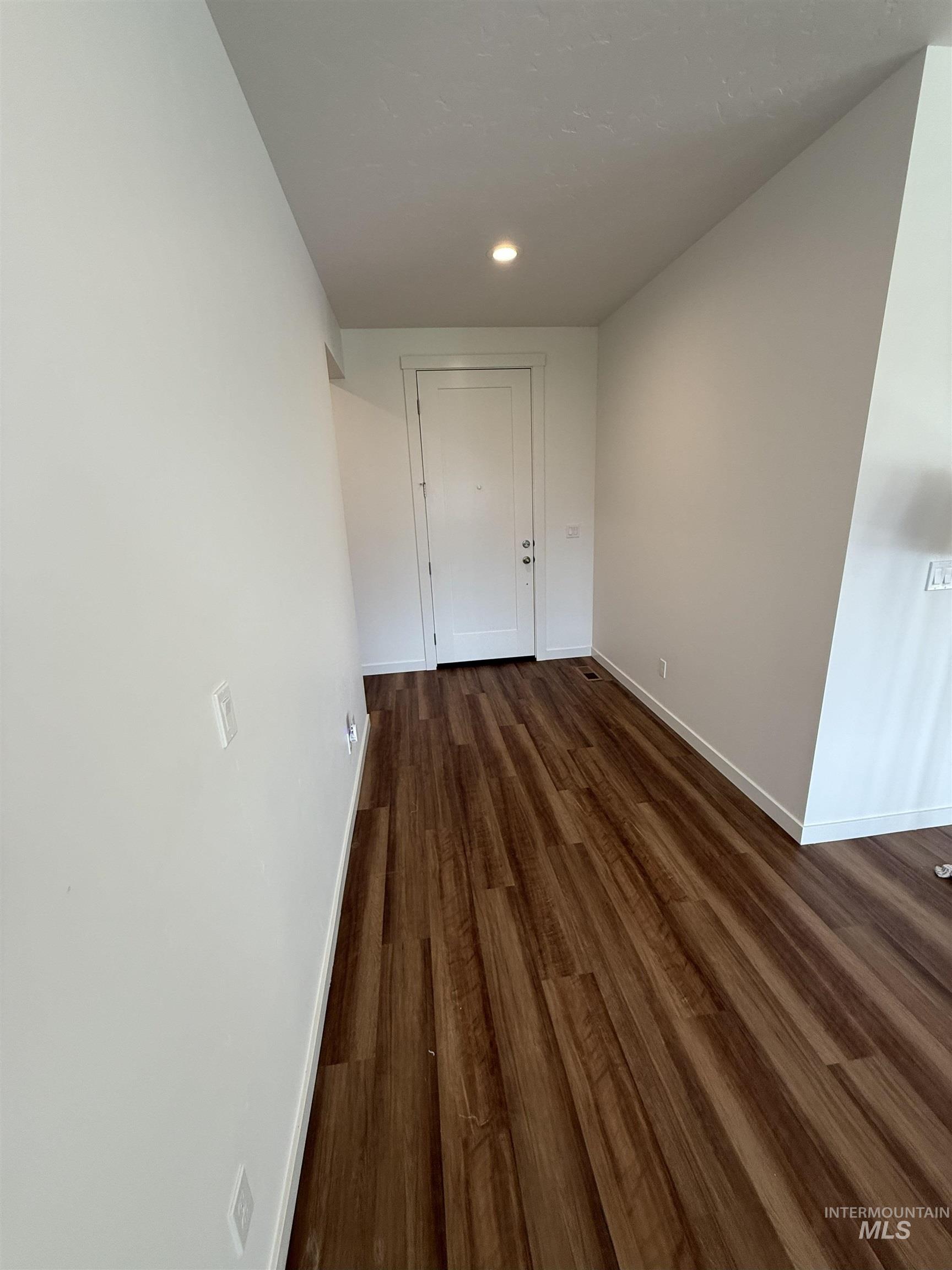 Unfurnished dining area with dark wood-type flooring and recessed lighting
