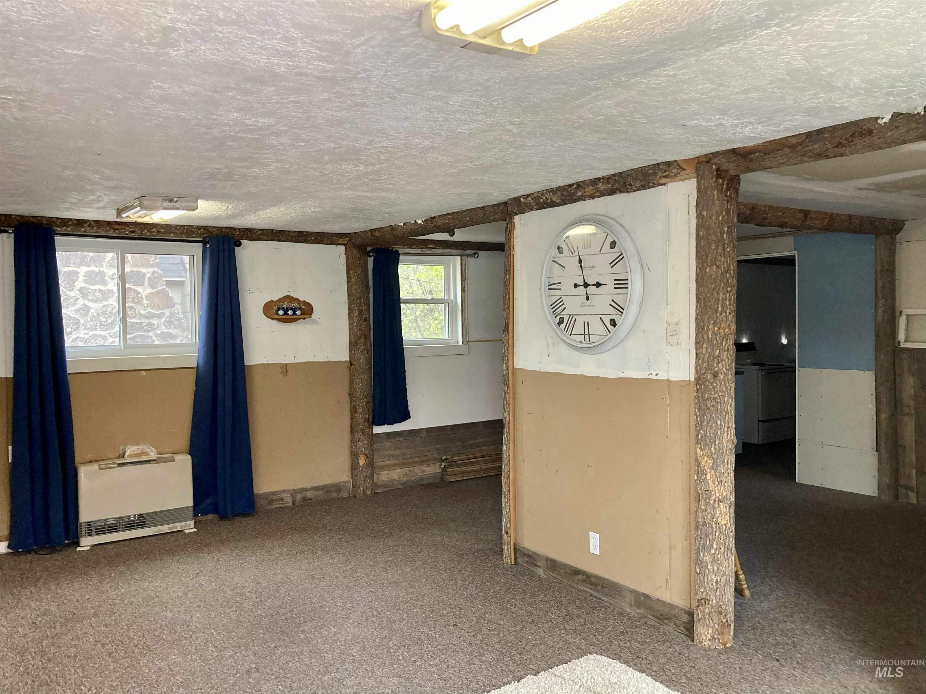 Spare room featuring carpet floors, heating unit, and a textured ceiling