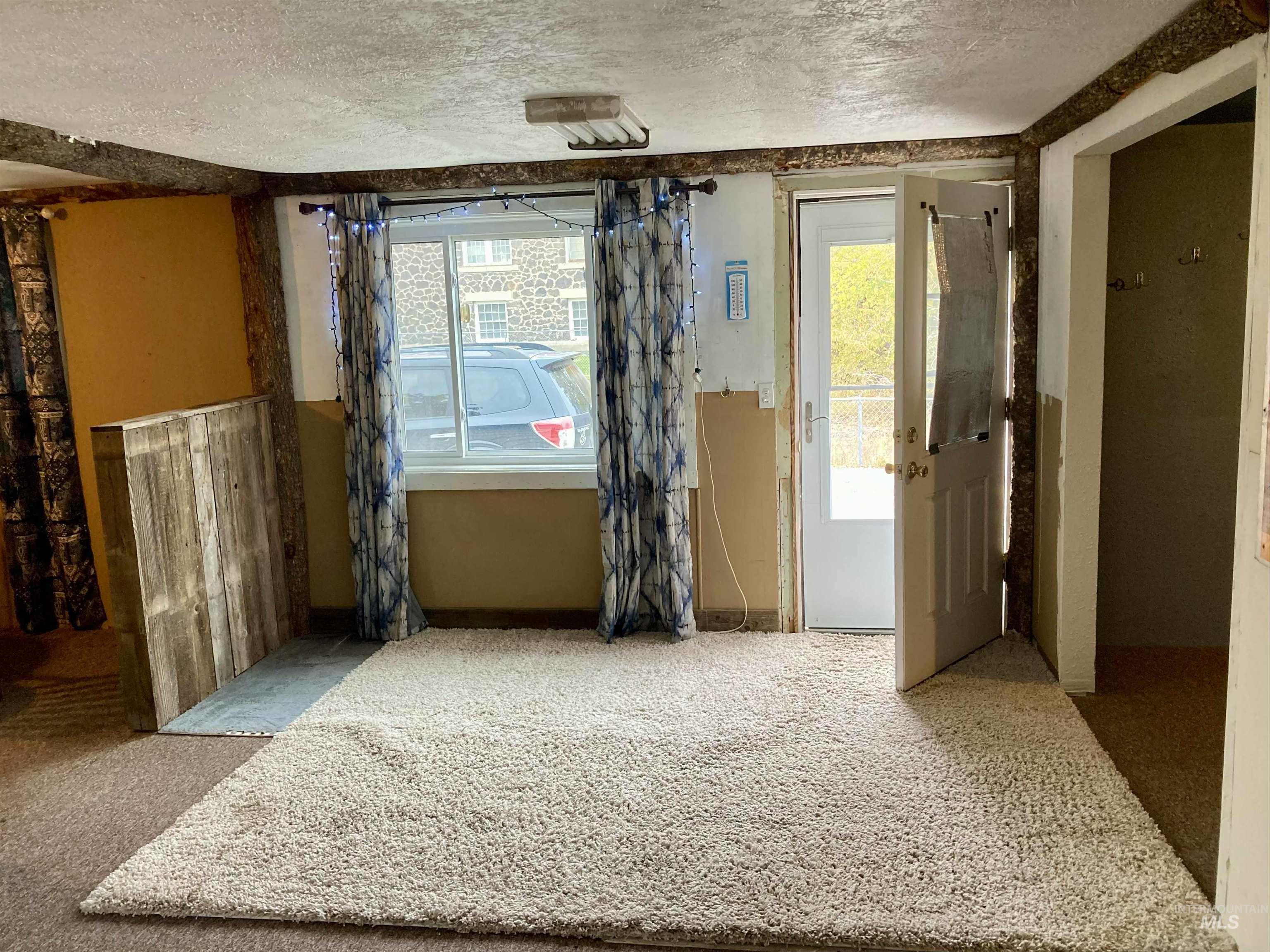 Unfurnished room with a textured ceiling and carpet