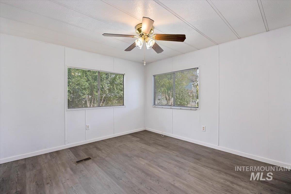 Empty room featuring wood finished floors and a ceiling fan