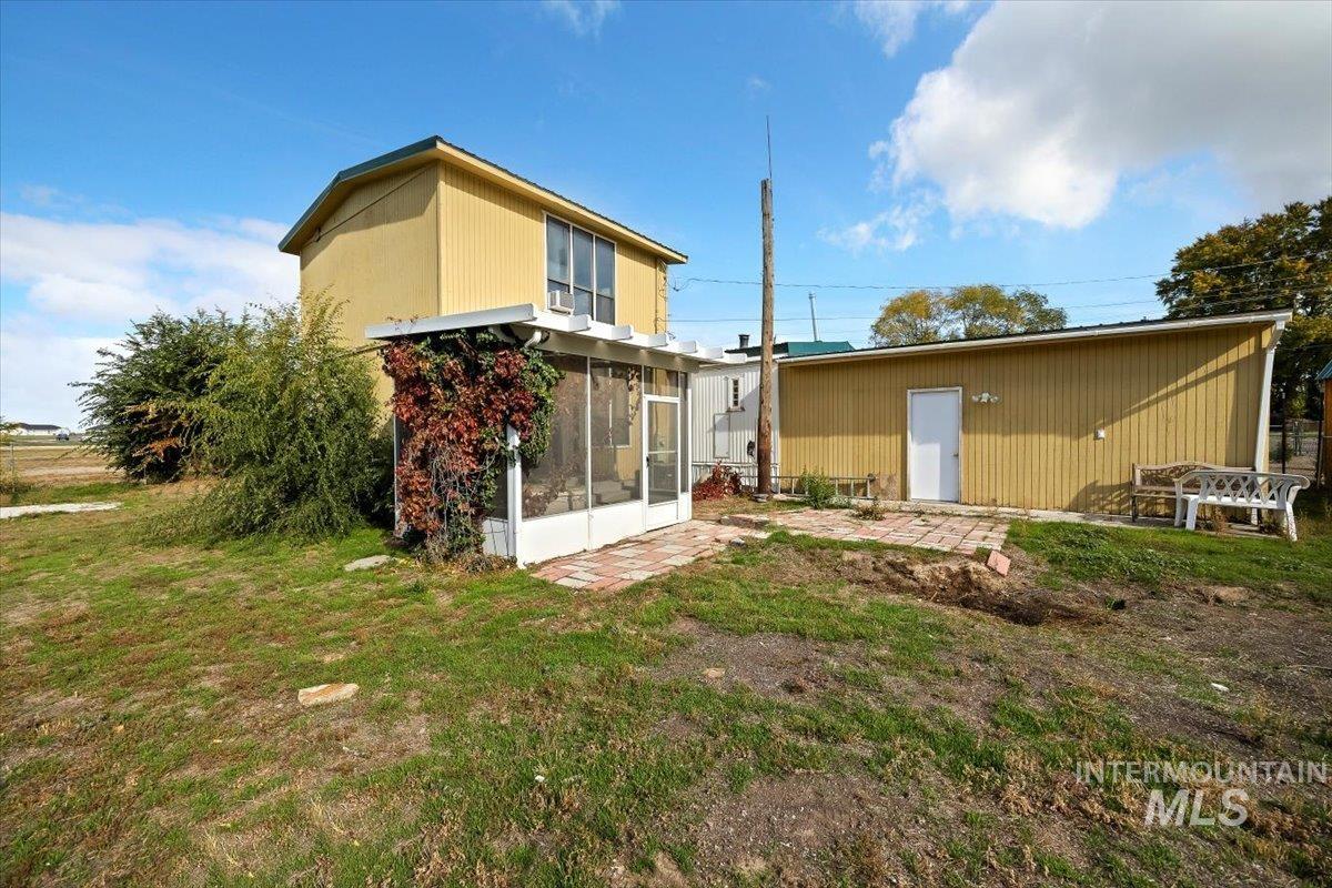 Back of house with a sunroom, a yard, and a patio