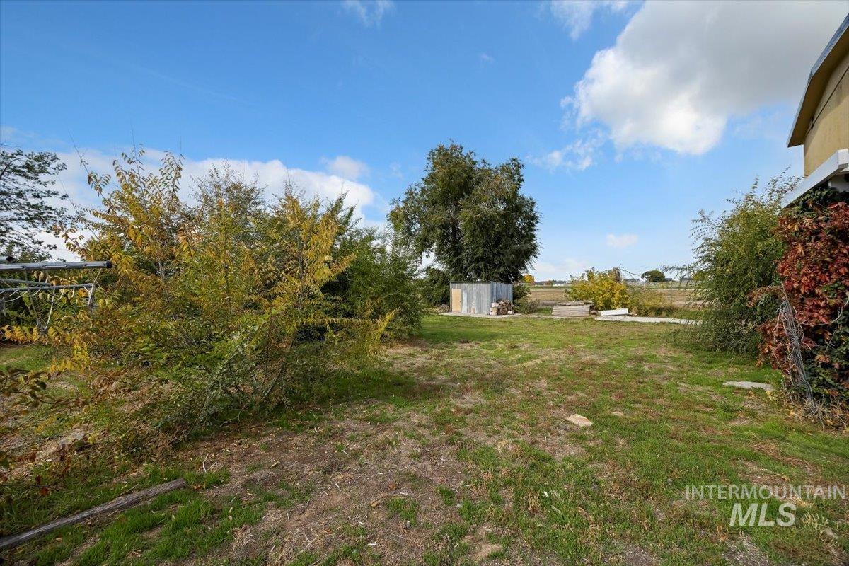View of grassy yard featuring an outdoor structure