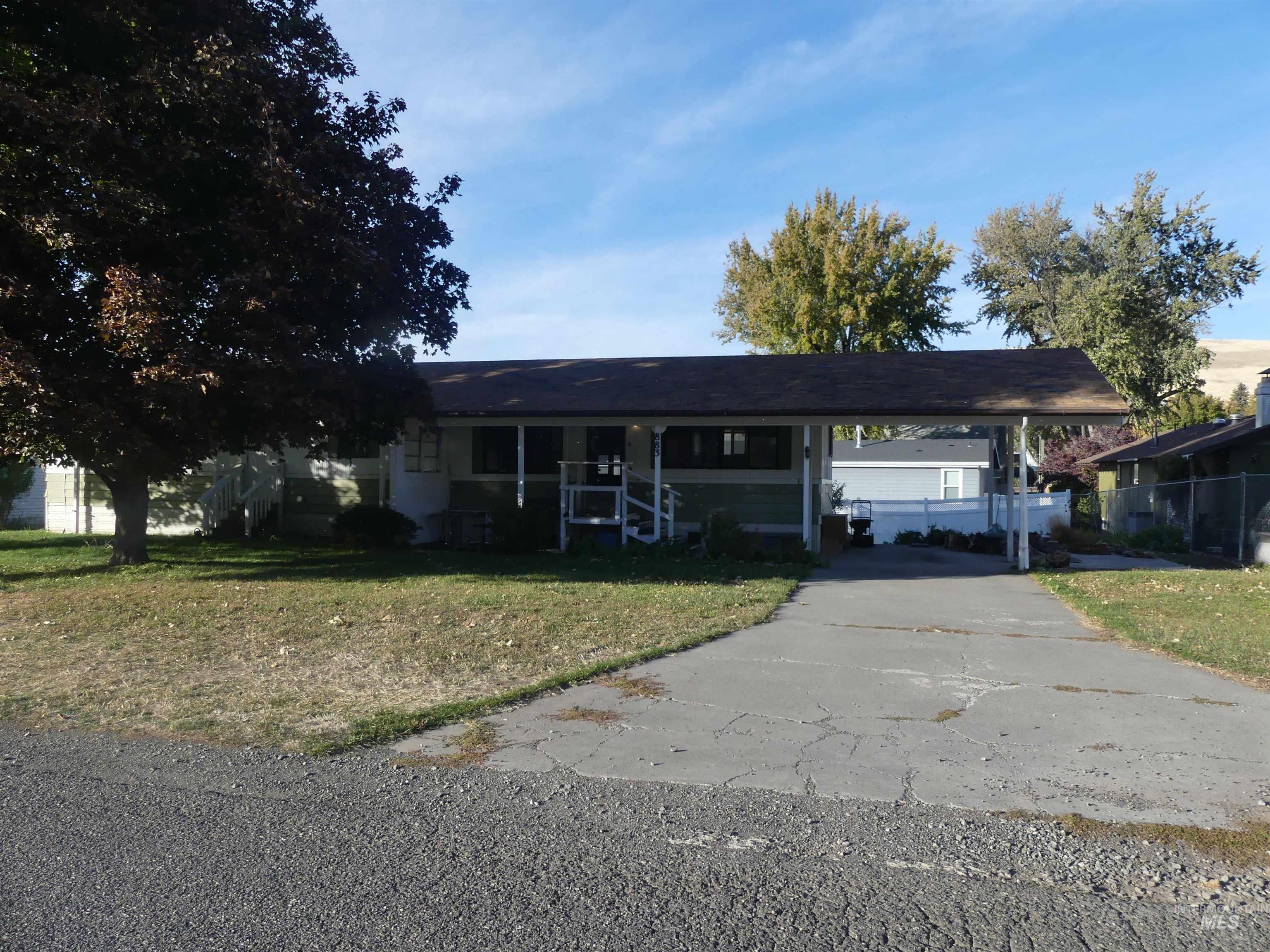 View of front of home with driveway, a carport, and covered porch