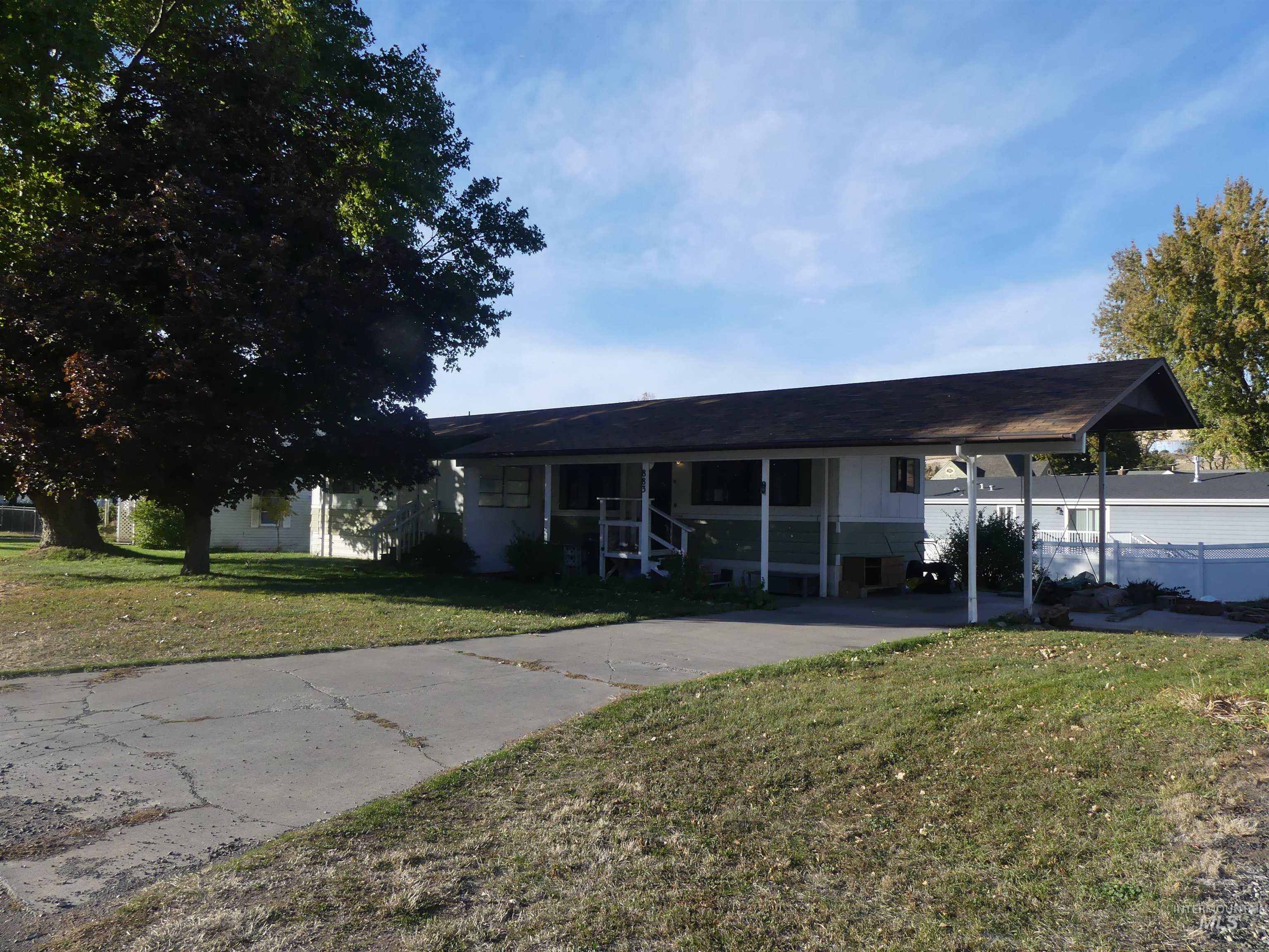 View of front of home featuring a carport, a front lawn, concrete driveway, and a porch