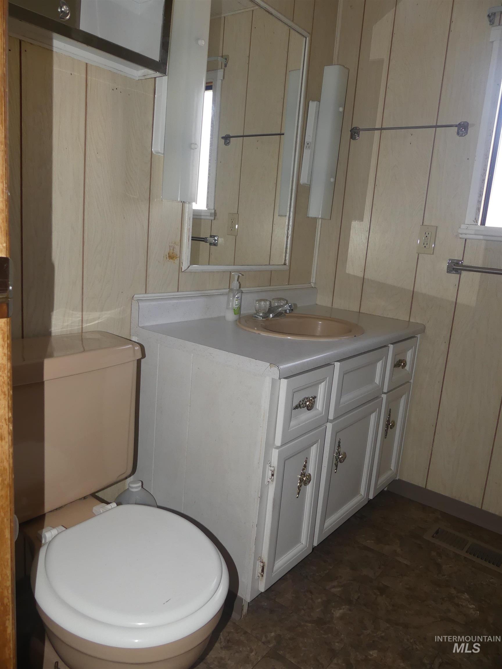 Half bathroom with vanity and toilet