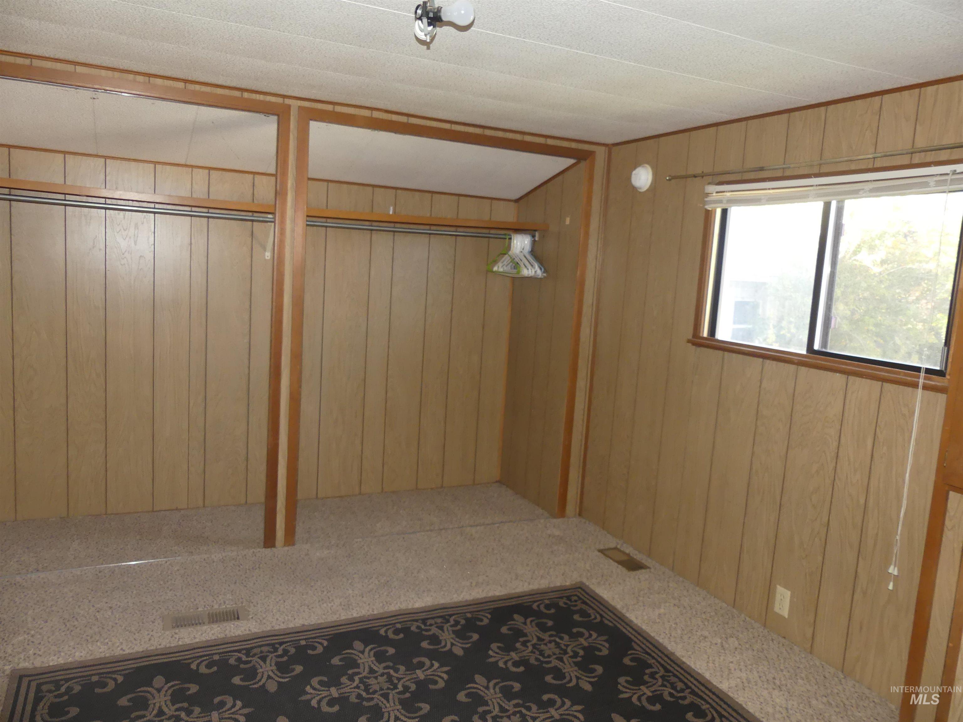 Mudroom with wood walls and carpet